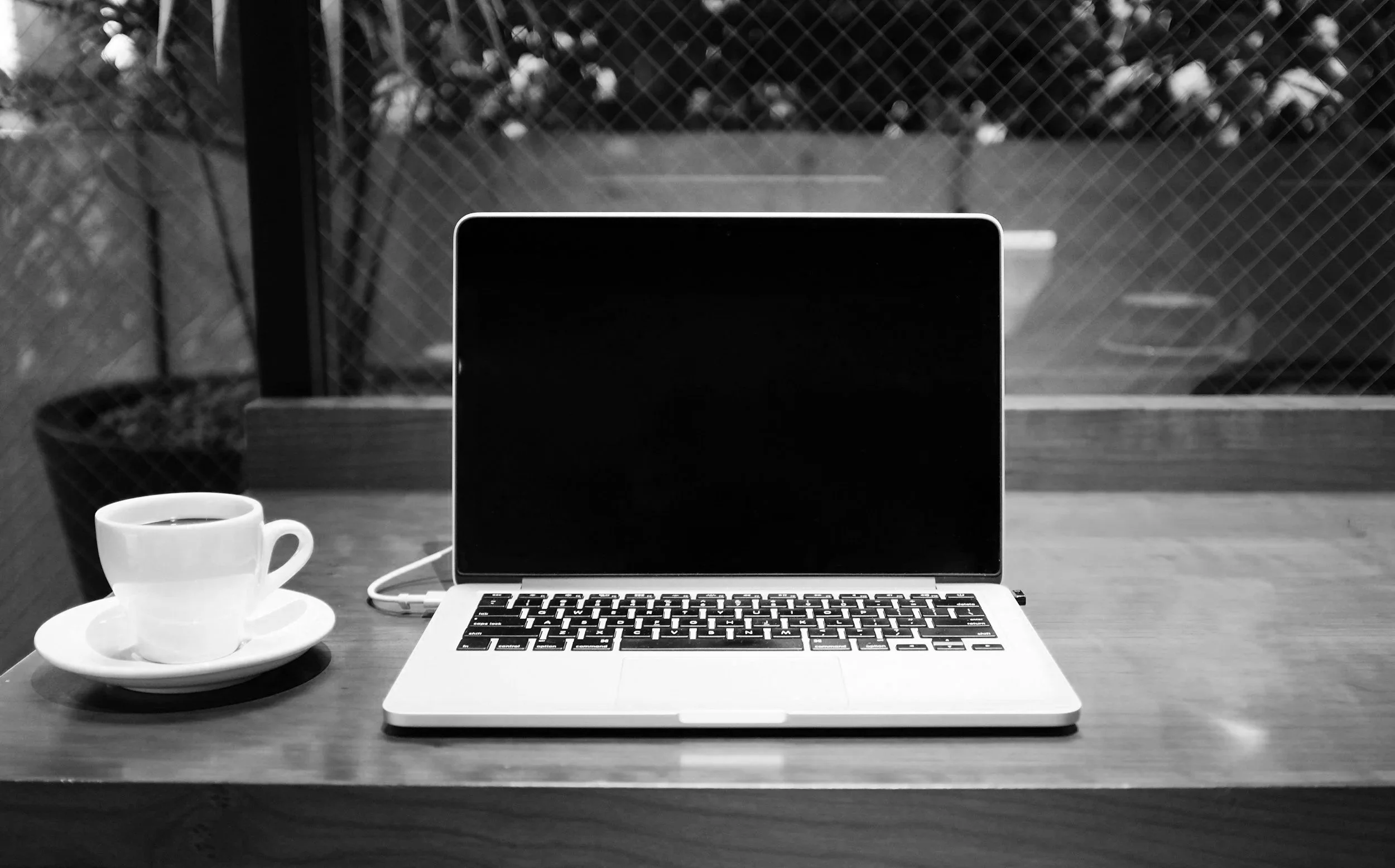 Jacqueline Fisch and intuitive writing partner laptop and coffee in black and white