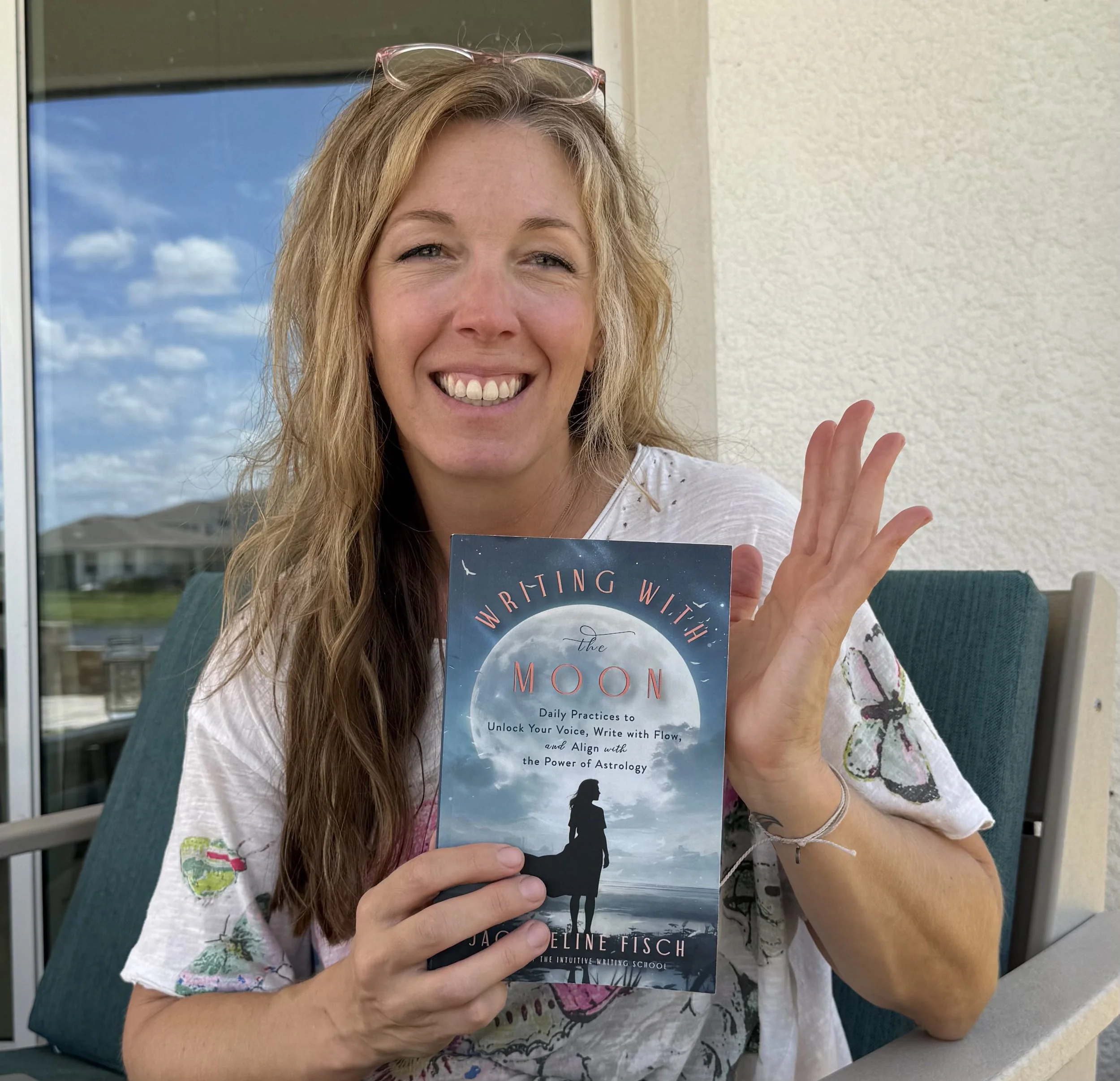 Author Jacqueline Fisch holding her book, Writing with the Moon