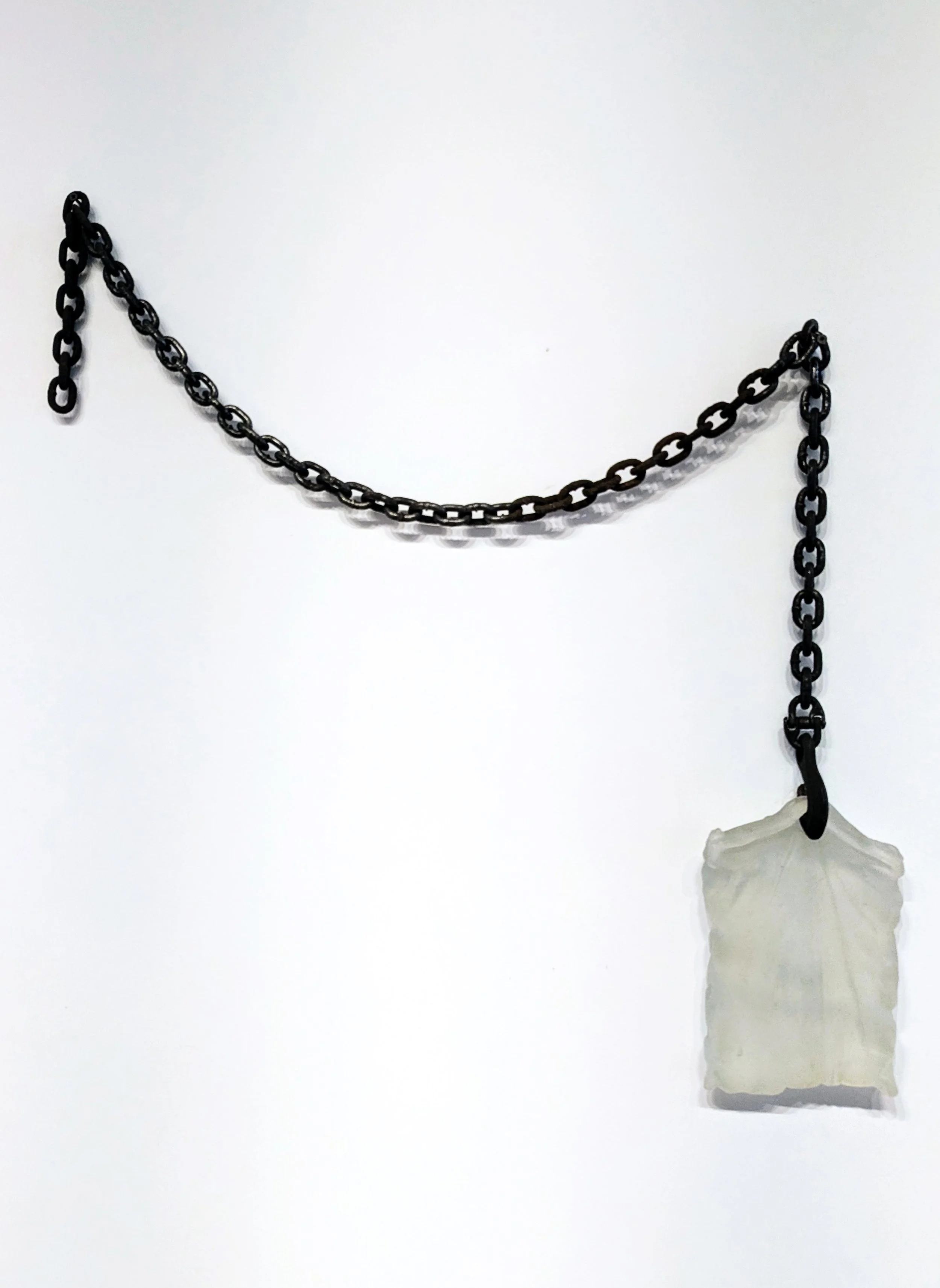 A black metal chain with a molded glass component, against a plain white background.