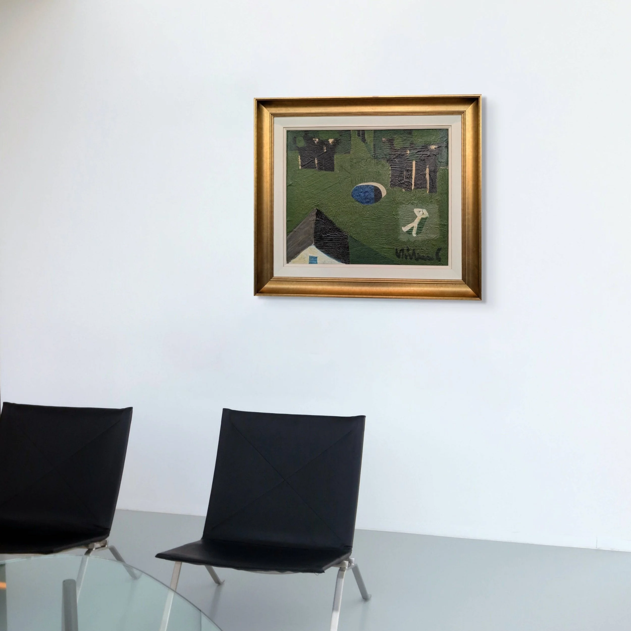 An art gallery with a white wall and a framed painting. There are two black chairs and a glass table in the foreground.