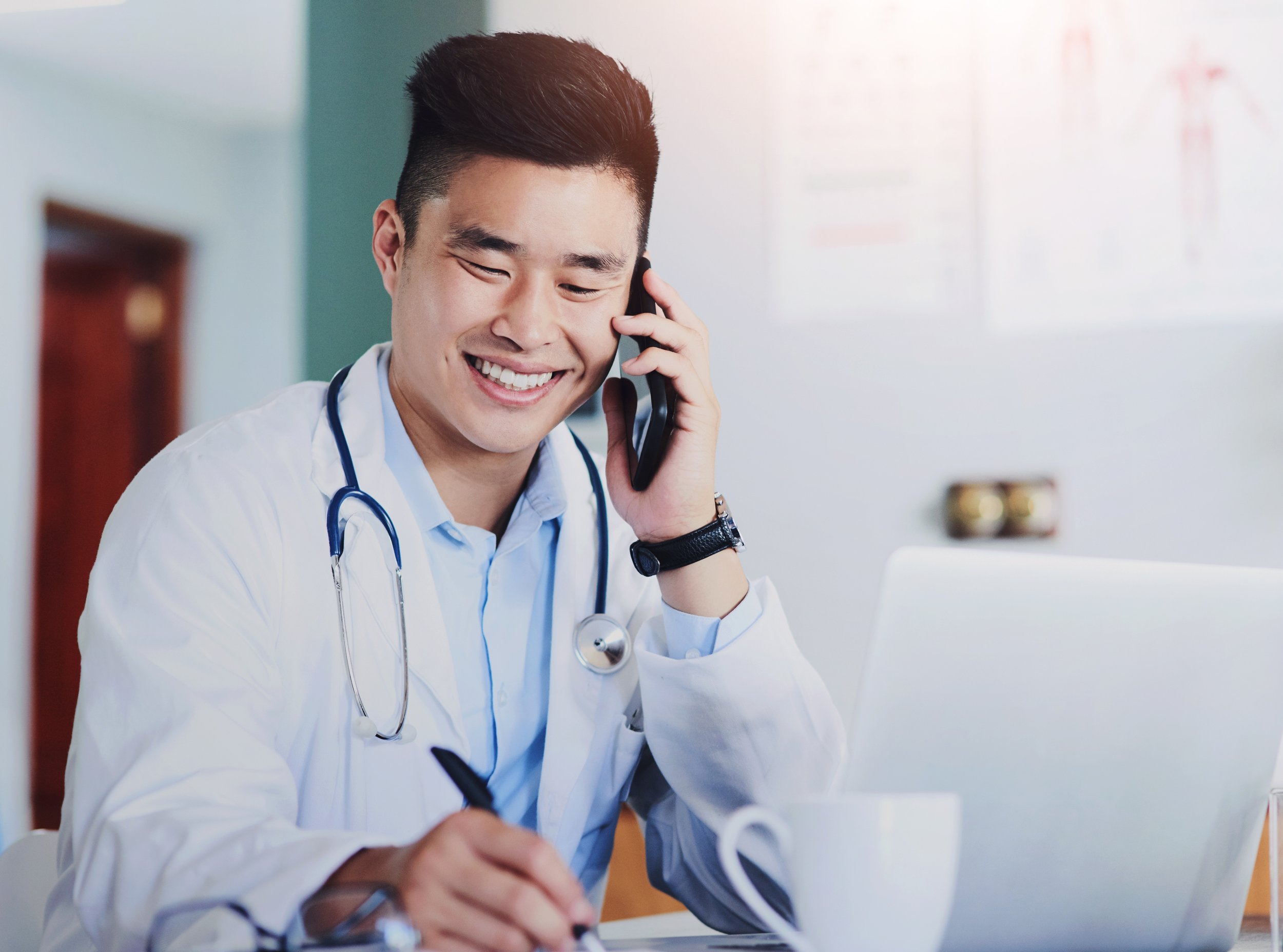 Physician discussing a claim by phone at a desk