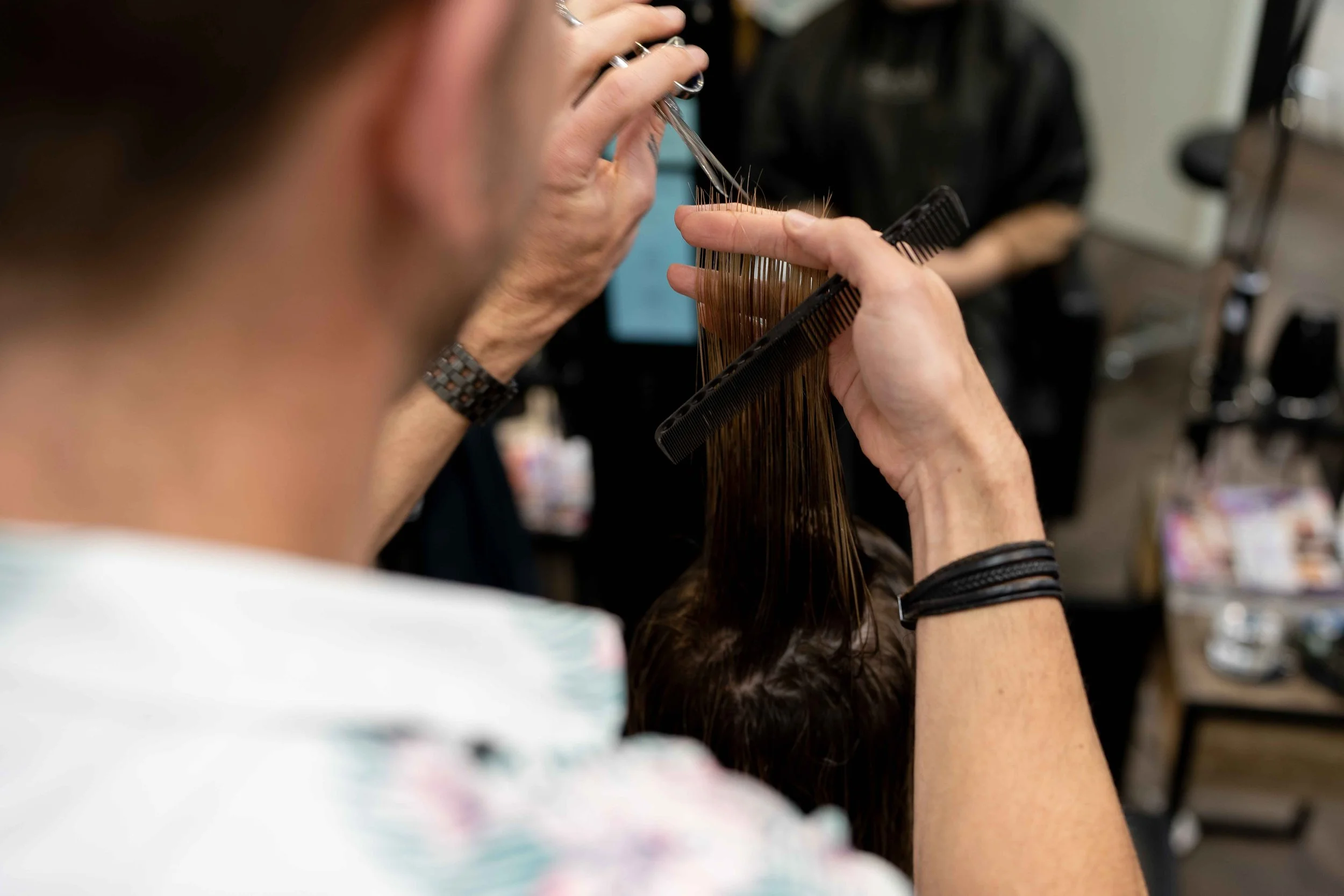 Stylist cutting a client’s long hair at Travis Hairdressing, a Blackwood hair salon offering personalised haircuts and styling.