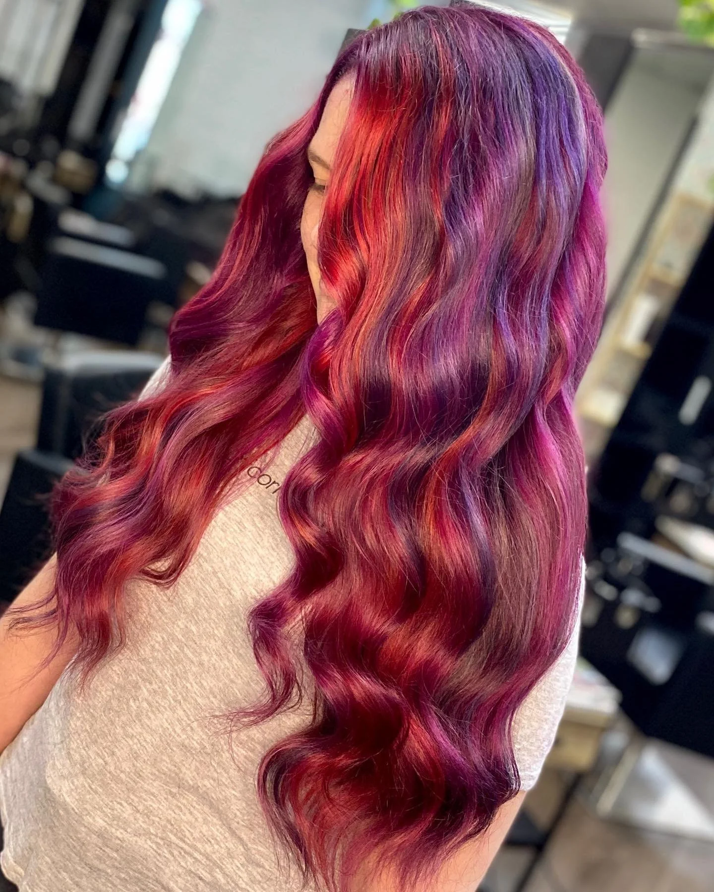 Vibrant pink and purple hair colour with soft waves created at Travis Hairdressing in Blackwood.