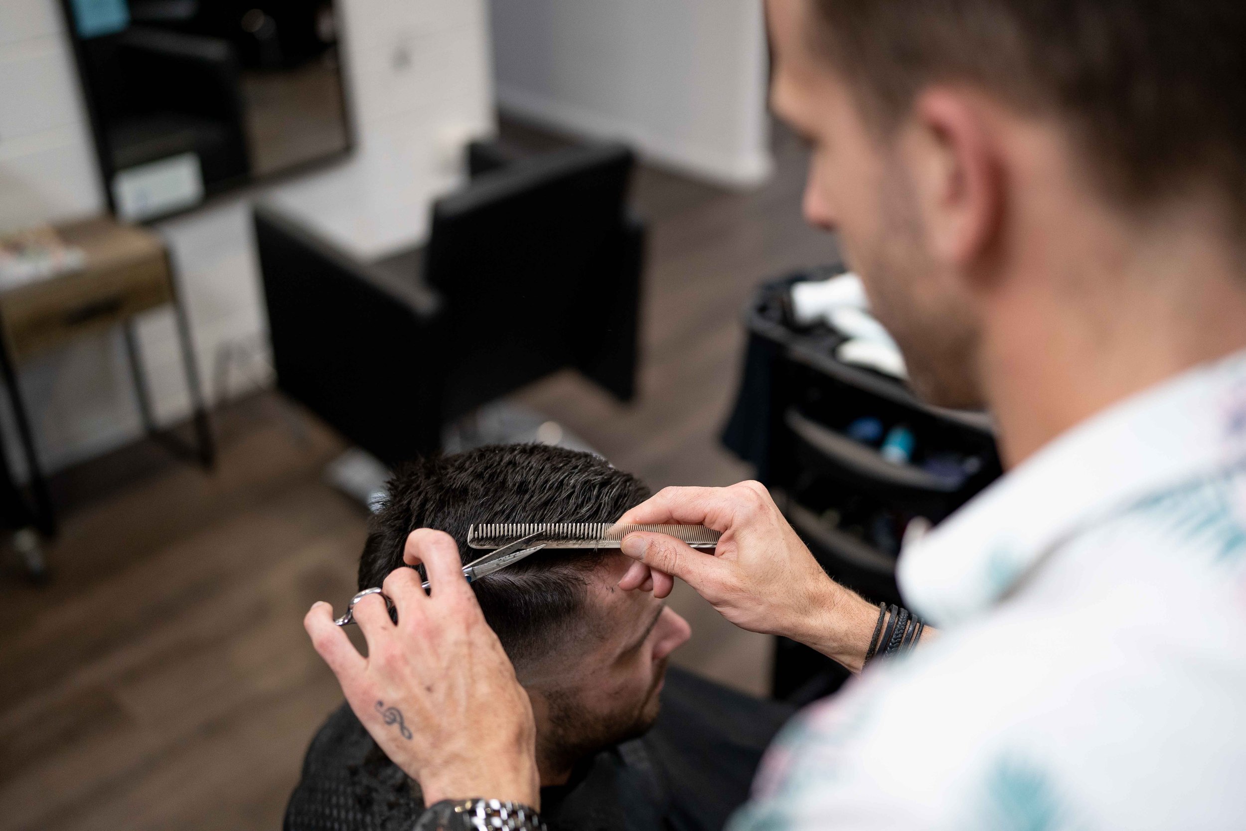 Hairdresser cutting a men’s hairstyle at Travis Hairdressing in Blackwood.