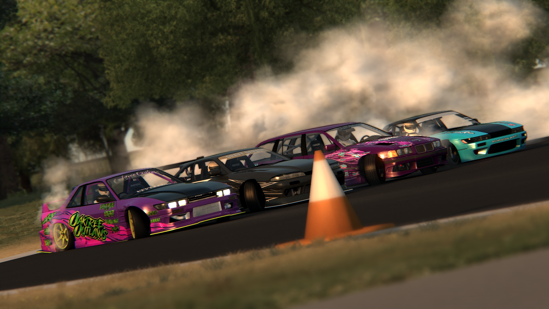 Four race cars in a drift race on a track, with smoke billowing from their tires, orange traffic cone on the track, and green trees in the background.