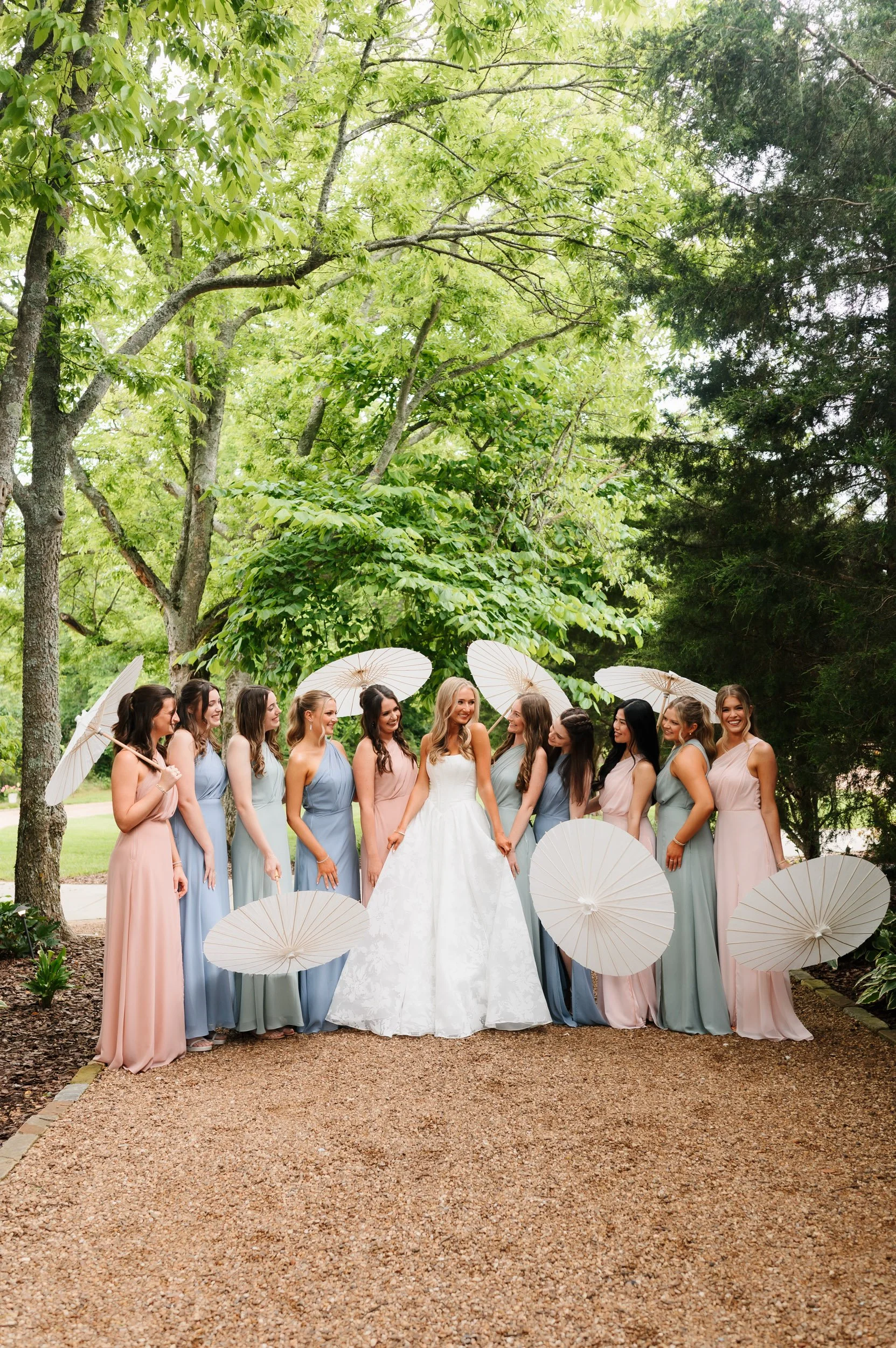 Bridesmaids posing together outdoors with parasols outdoors during wedding day at Southall Meadows in Franklin Tennessee