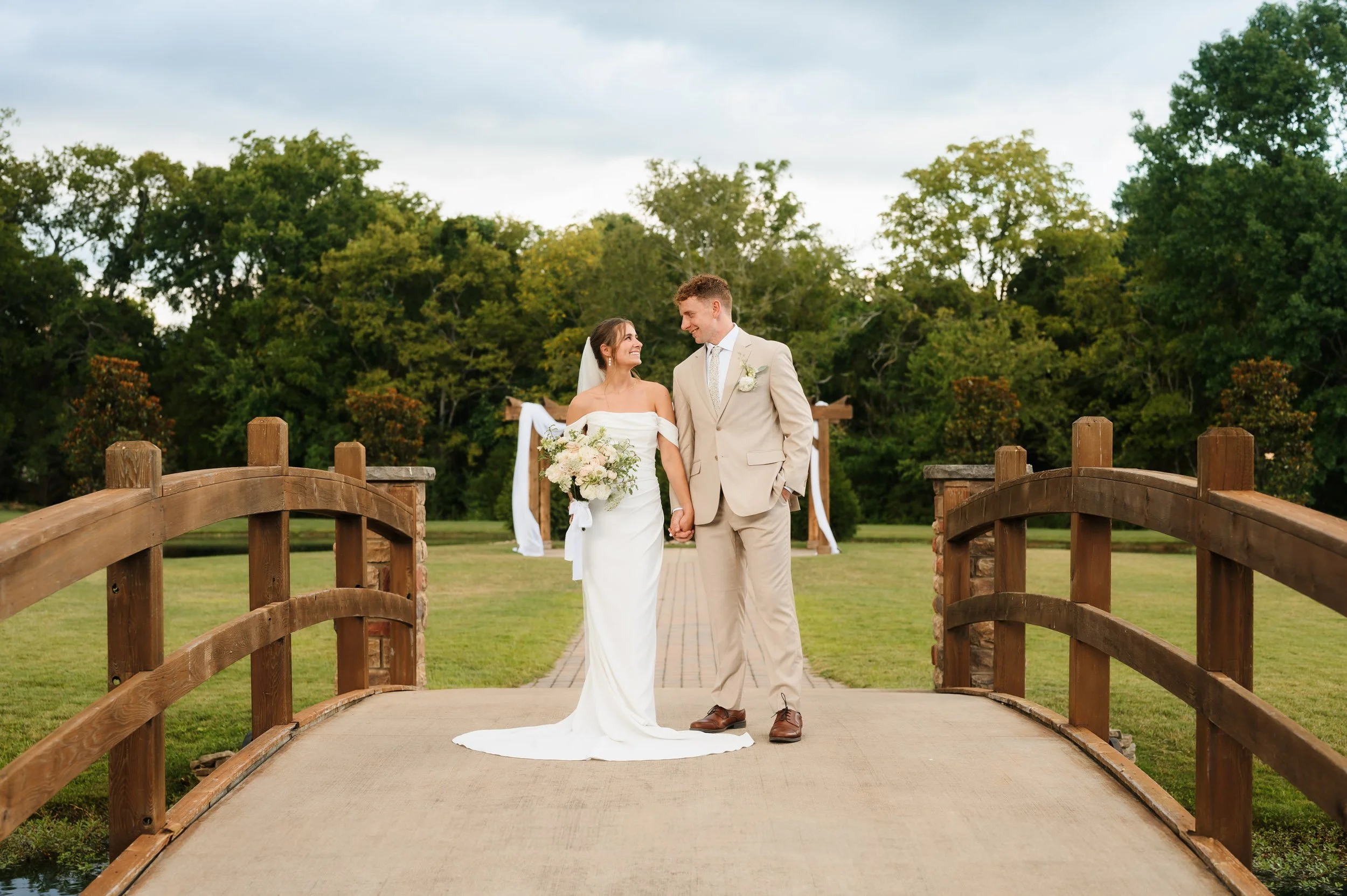 Bride and groom posing together on a bridge outdoors during wedding day in Franklin Tennessee