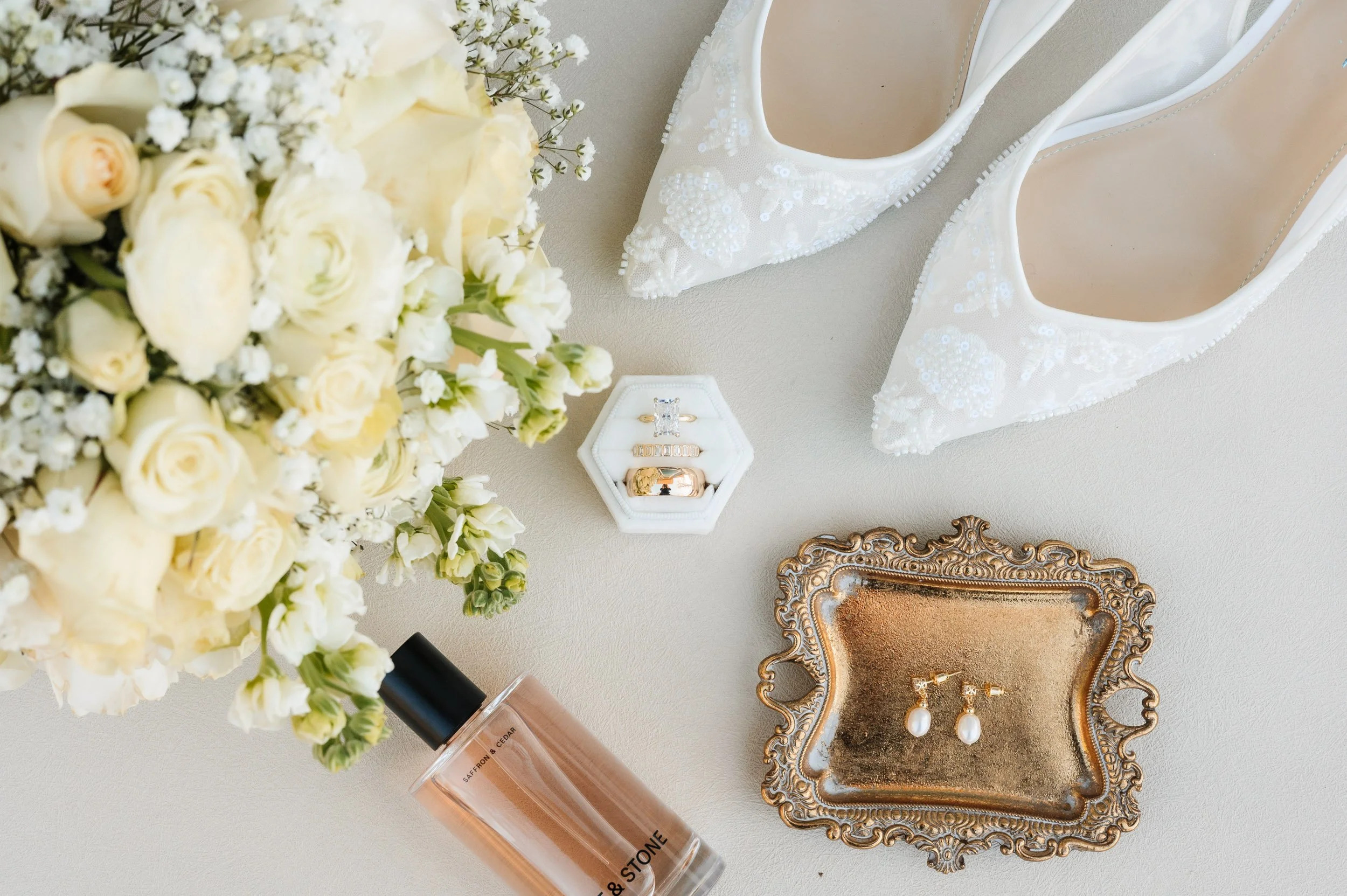 Luxury bridal flat lay photograph with white floral bouquet and wedding accessories