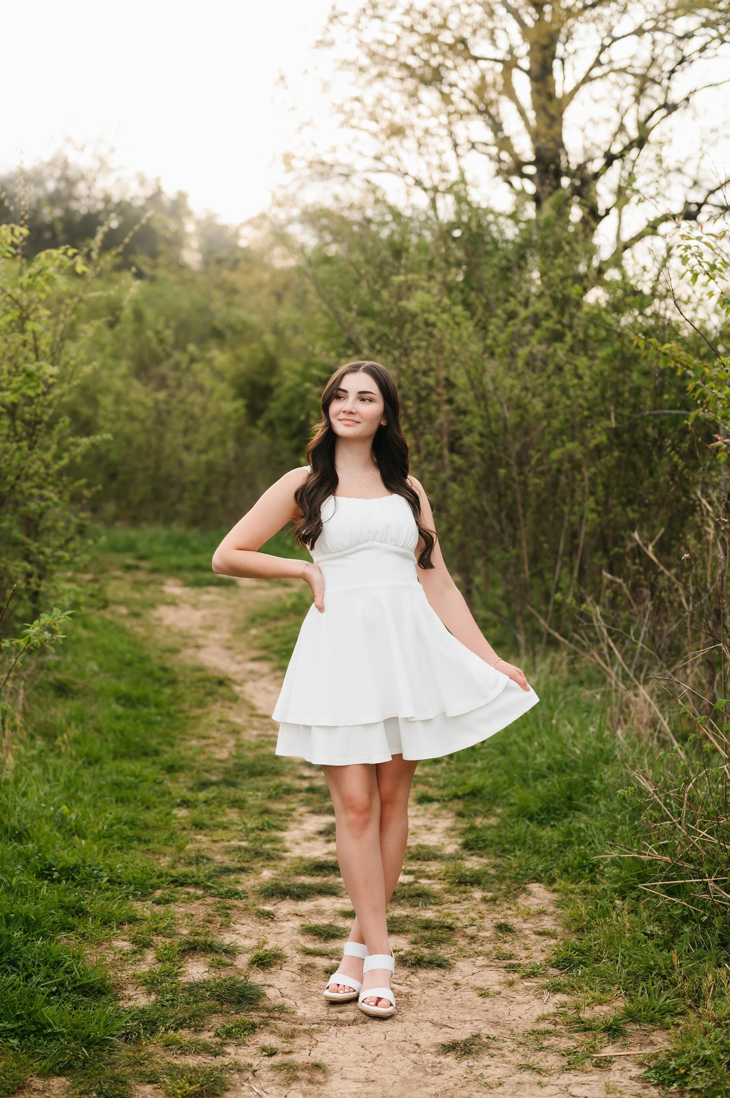 High school senior girl in white dress posing outdoors during Franklin Tennessee portrait session