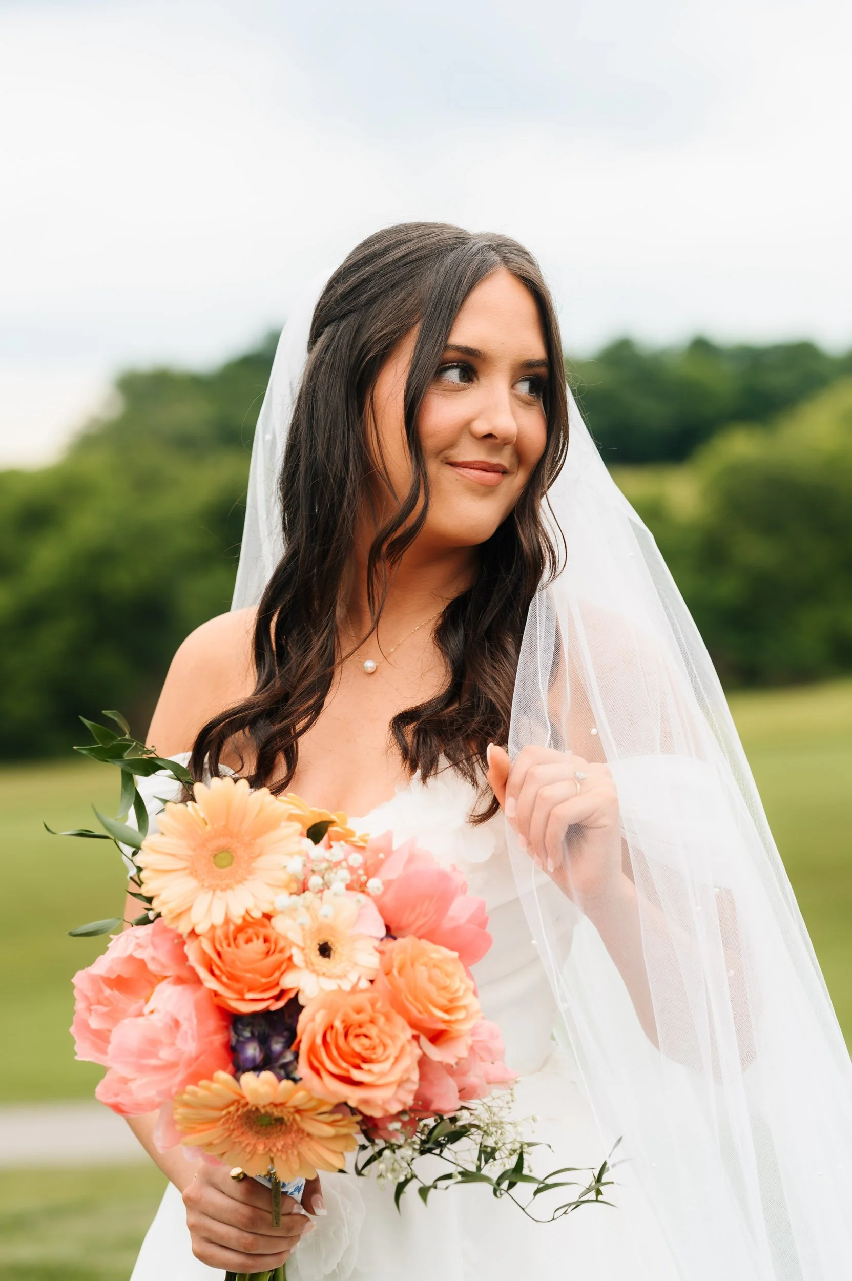 Bride holding colorful bouquet & veil during outdoor tennessee wedding bridal session