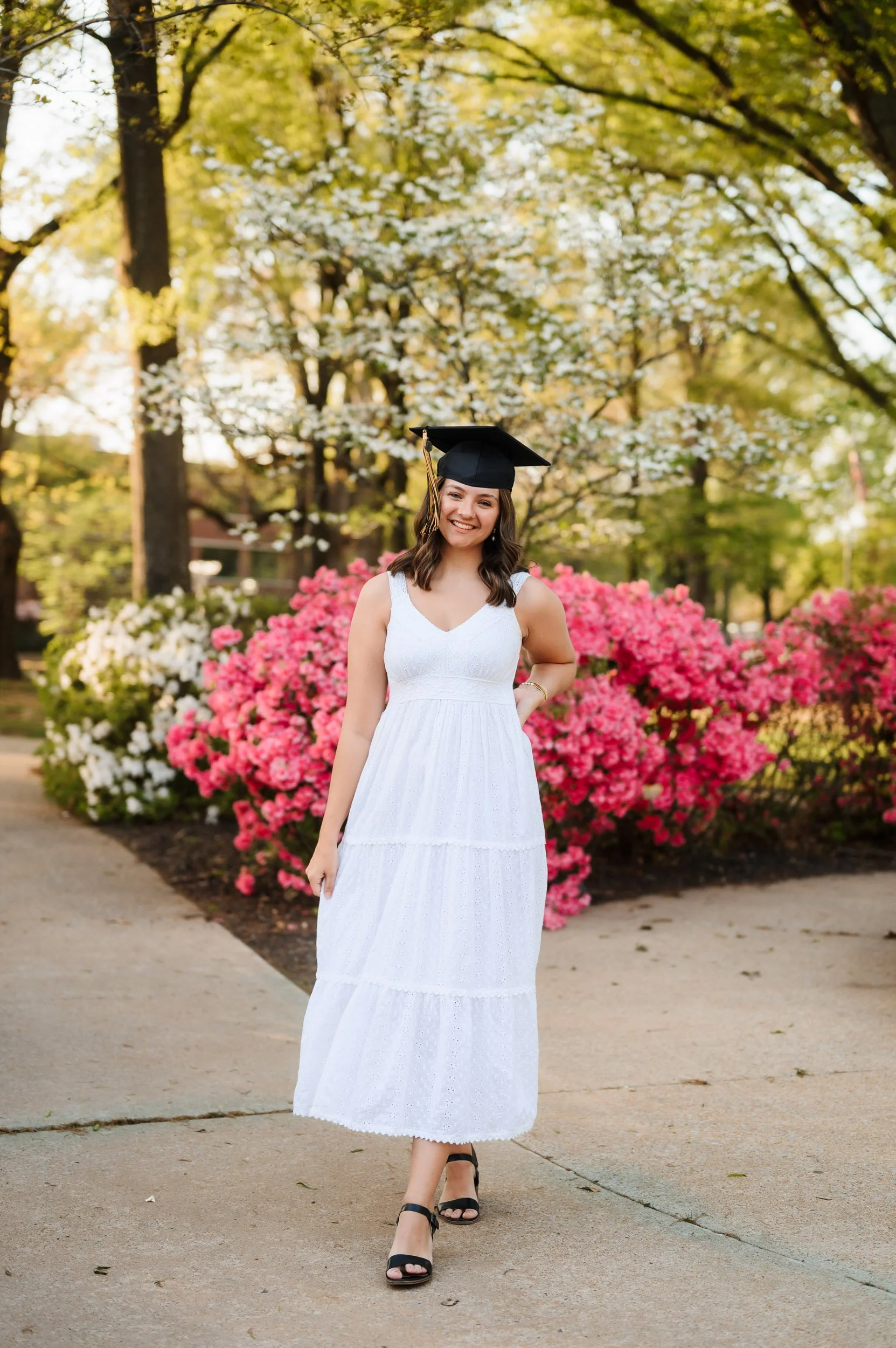 College graduate girl standing outdoors during spring portrait session in Nashville