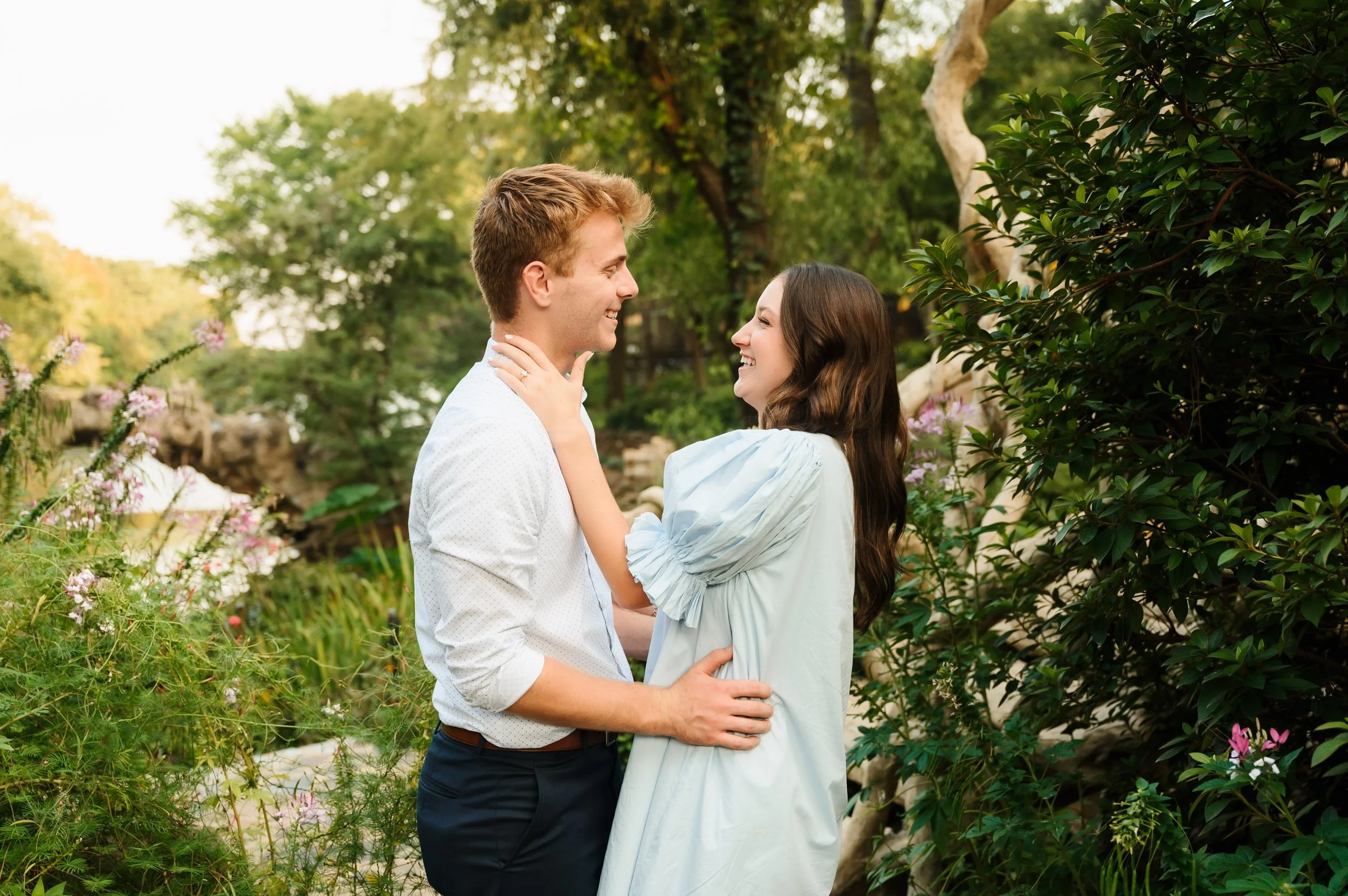 Couple embracing in garden with engagement ring during outdoor proposal session