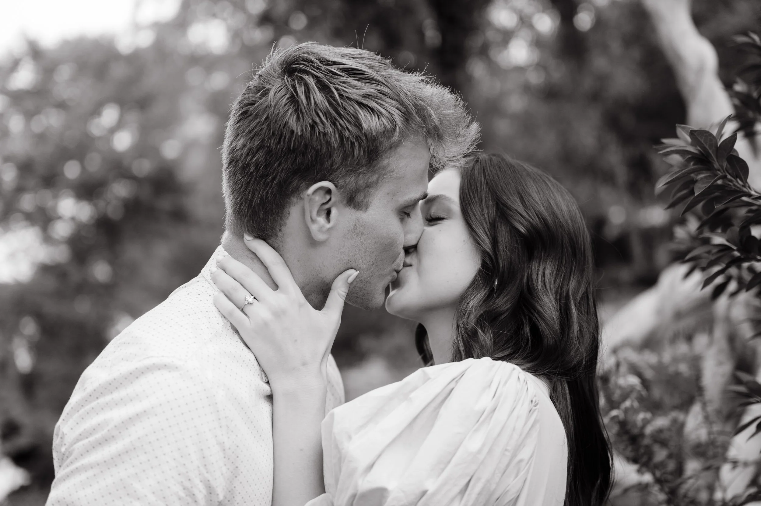 Black and white close-up portrait of couple embracing outdoors