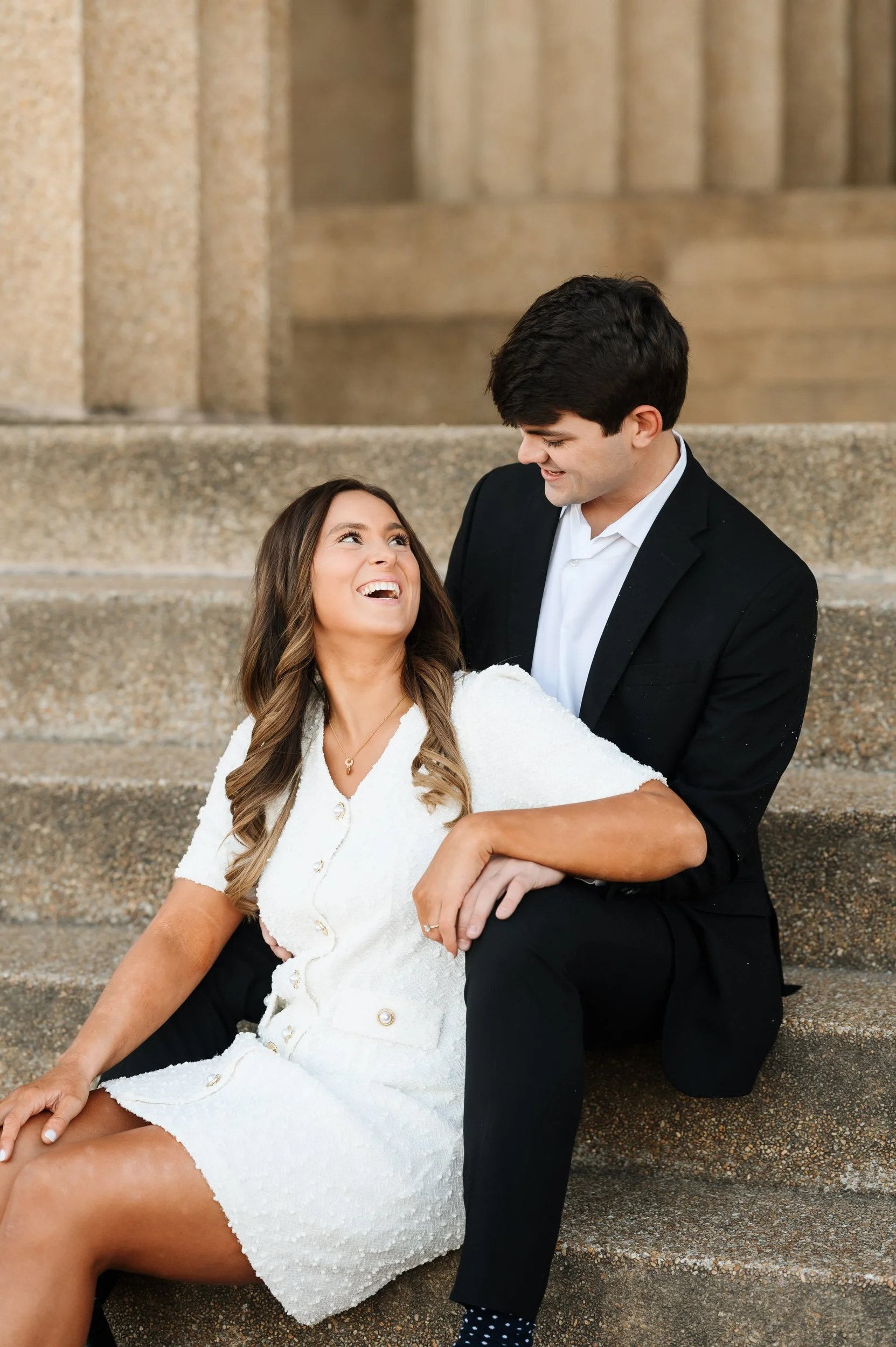 Couple sitting together on downtown Nashville Parthenon stairs during portrait session at Centennial Park