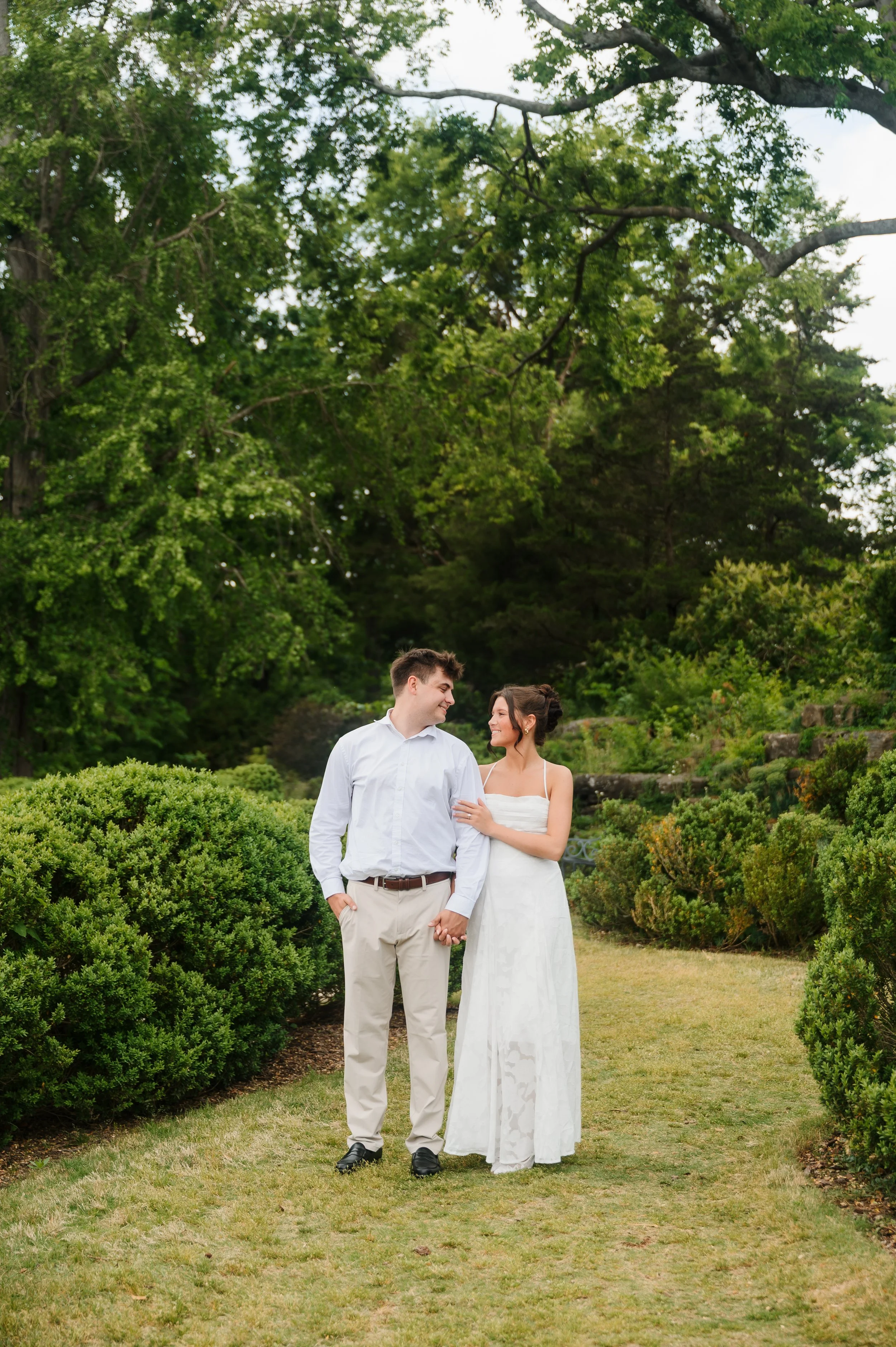 Couple embracing outdoors during engagement portrait session at Cheekwood in Tennessee