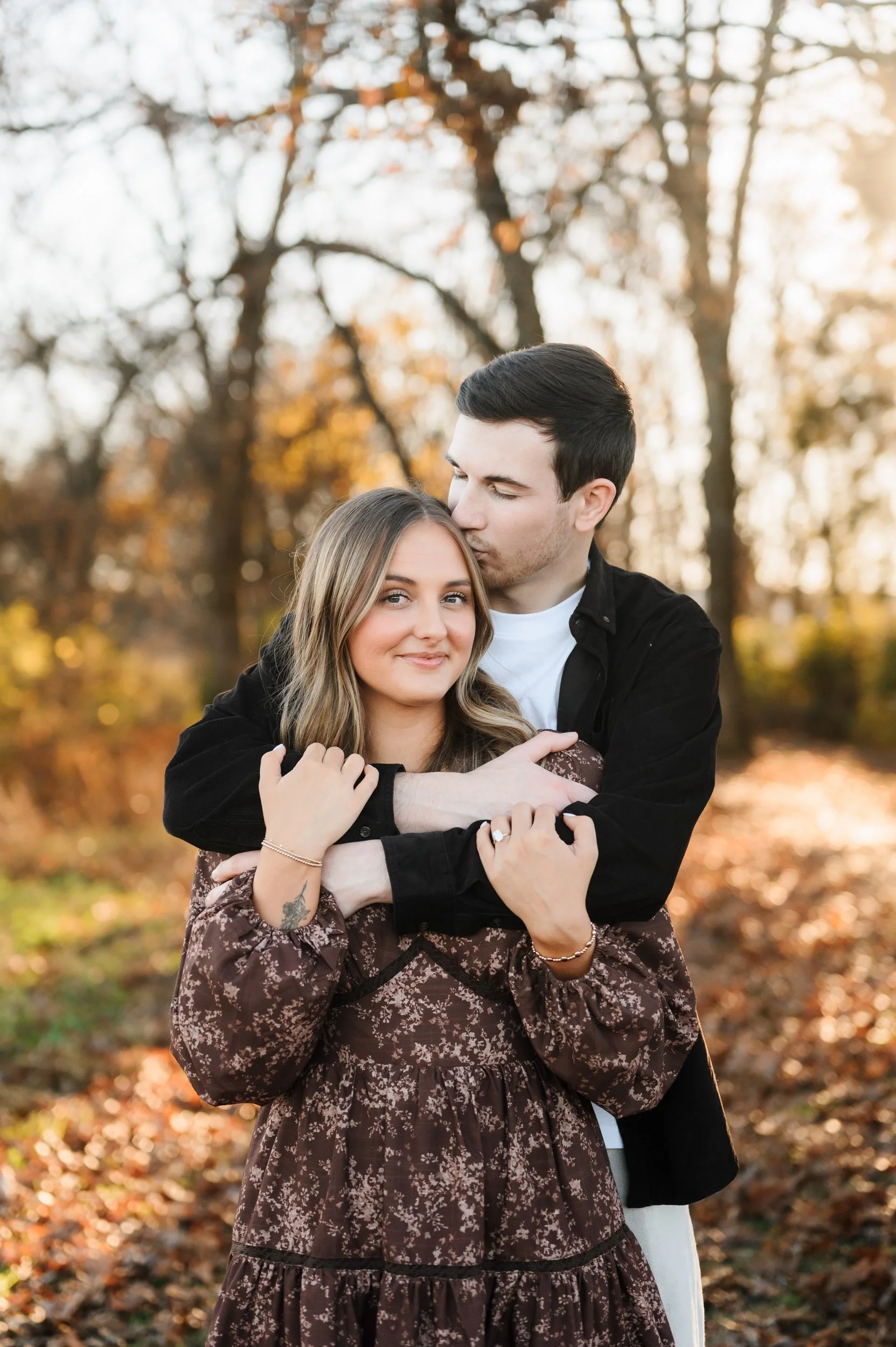A newly engaged couple embracing outdoors during fall proposal session in Tennessee