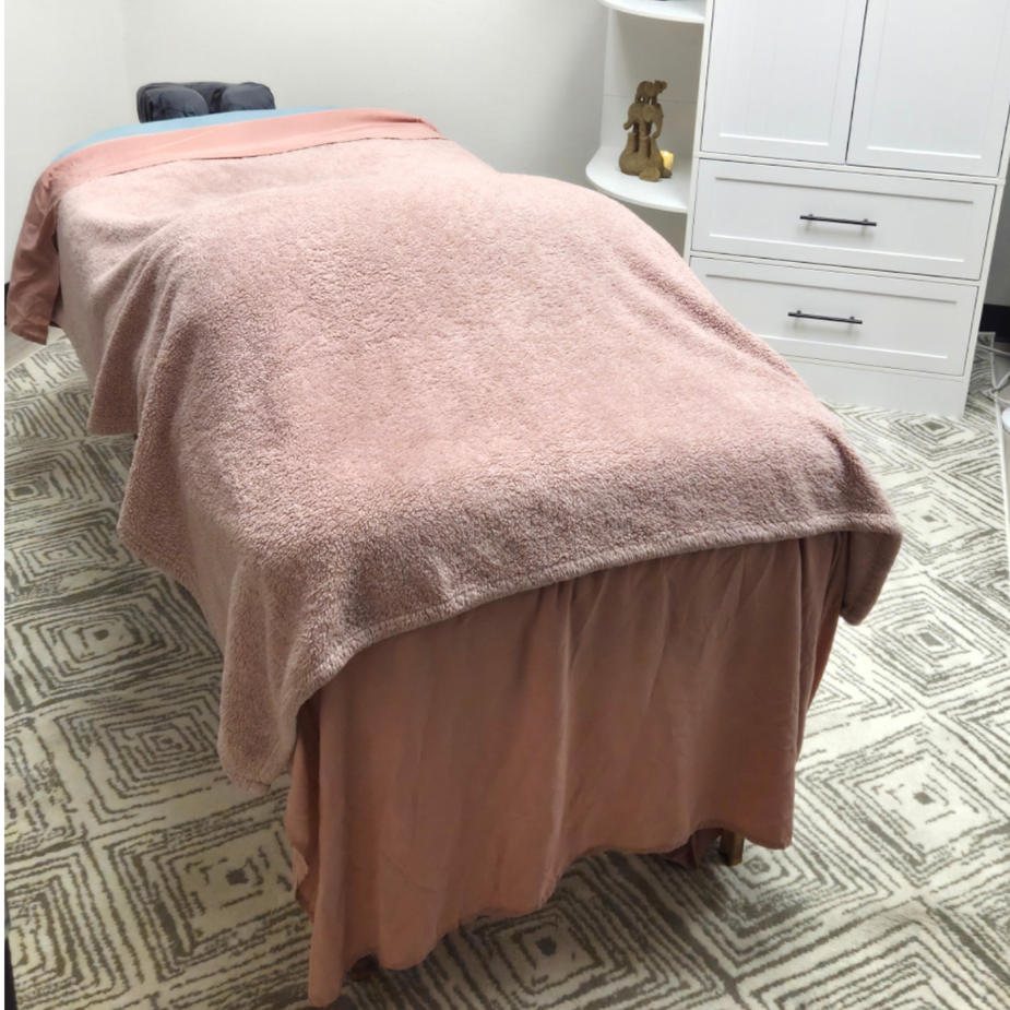 Massage table prepared with rose-colored linens at Tranquility Peace Massage in Tucson.