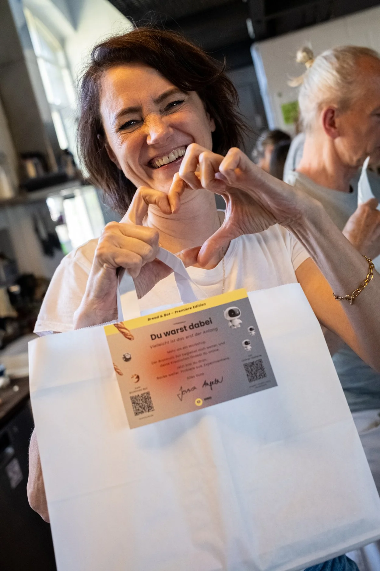 Teilnehmerin der Bread & Bot Experience mit Goodie Bag und persönlichem Workshop-Ergebnis.