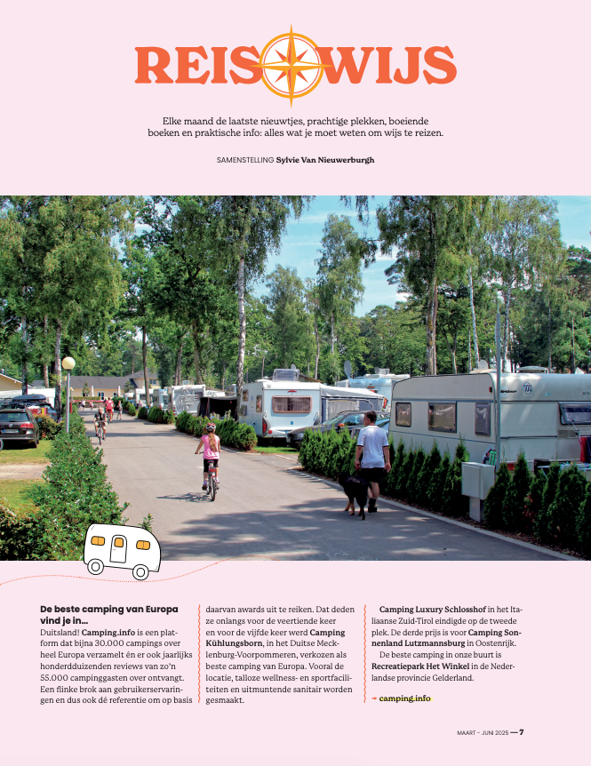 A camping site with numerous caravans parked among tall trees, with people walking and riding bikes on a paved path.