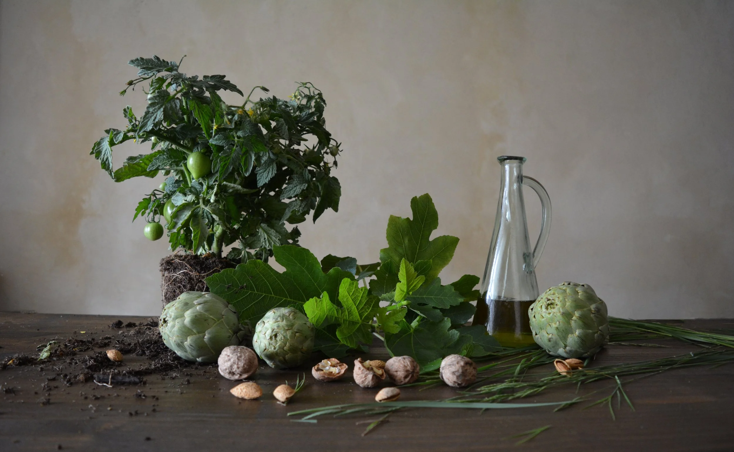 Bodegón compuesto por tomatera,alcachofa hojas de higuera y frutos secos con aceitera