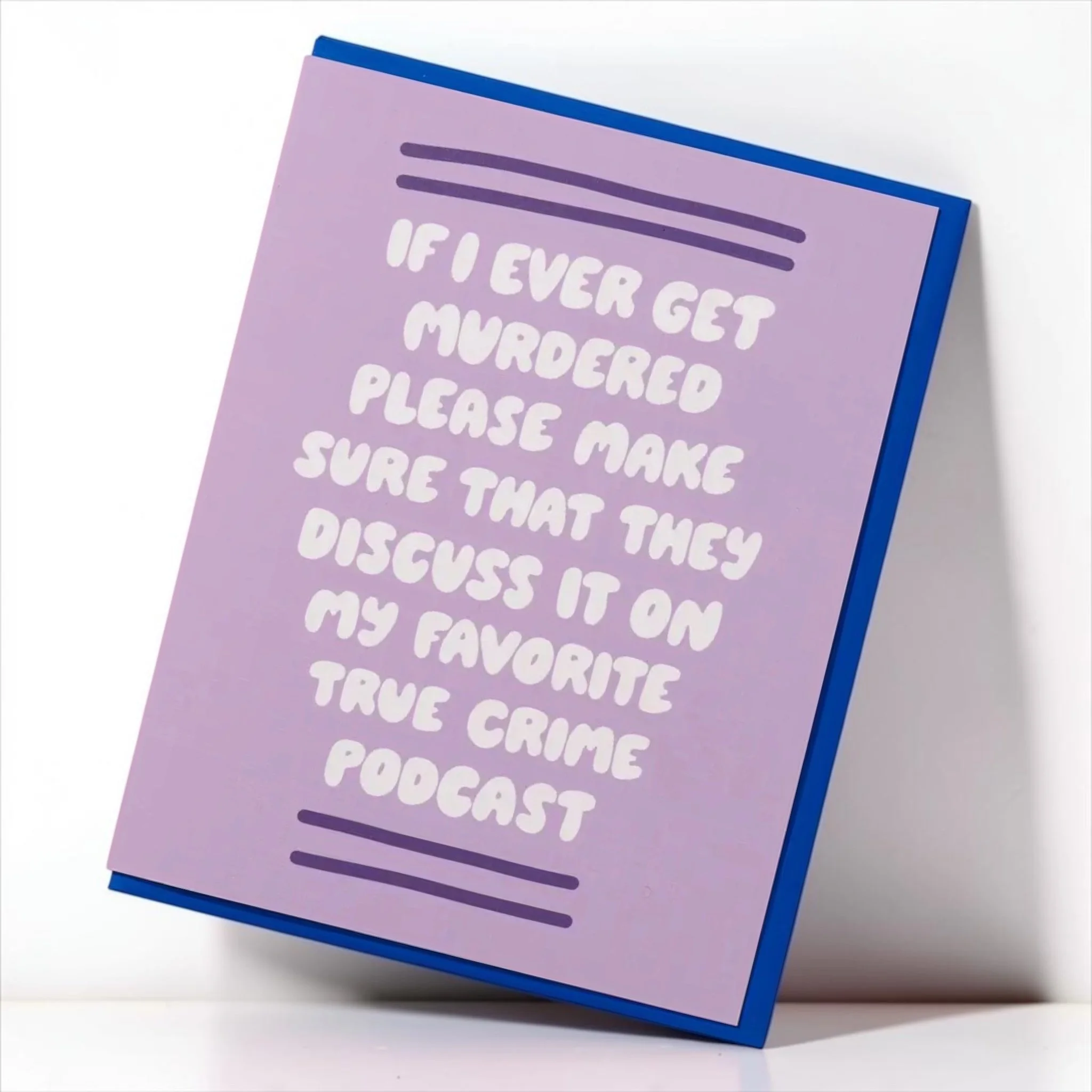 Angled view of a funny lavender true crime greeting card reading “If I ever get murdered please make sure that they discuss it on my favorite true crime podcast,” with a blue envelope.