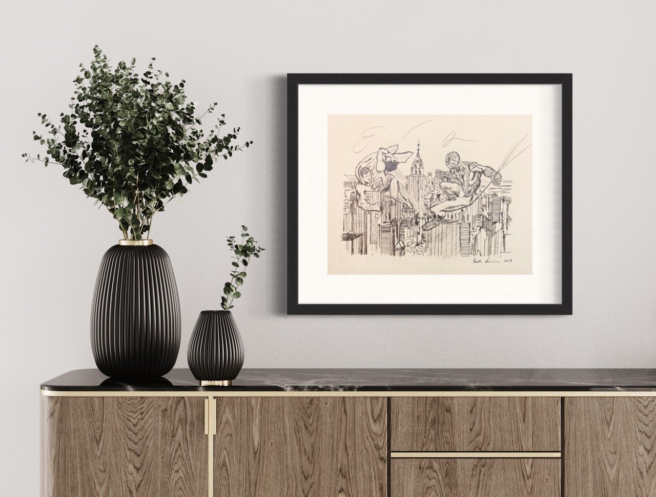 "A framed artwork by Kristin Simmons, displaying marvel superhoes in mid-battle above the NYC skyline, set against a light wall and above a wooden sideboard."