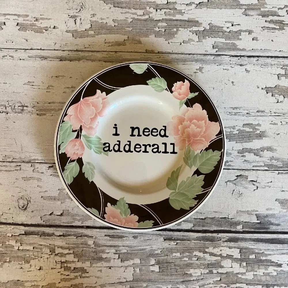 Artistic and whimsical plate with a vintage style and cheeky statement, ideal for playful decoration.