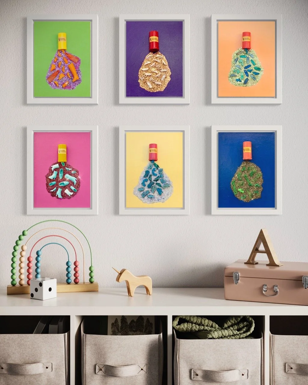 Six brightly colored canvases with pill bottles spilling out barbie shoes and glitter hanging in white frames on the wall of a children's room.