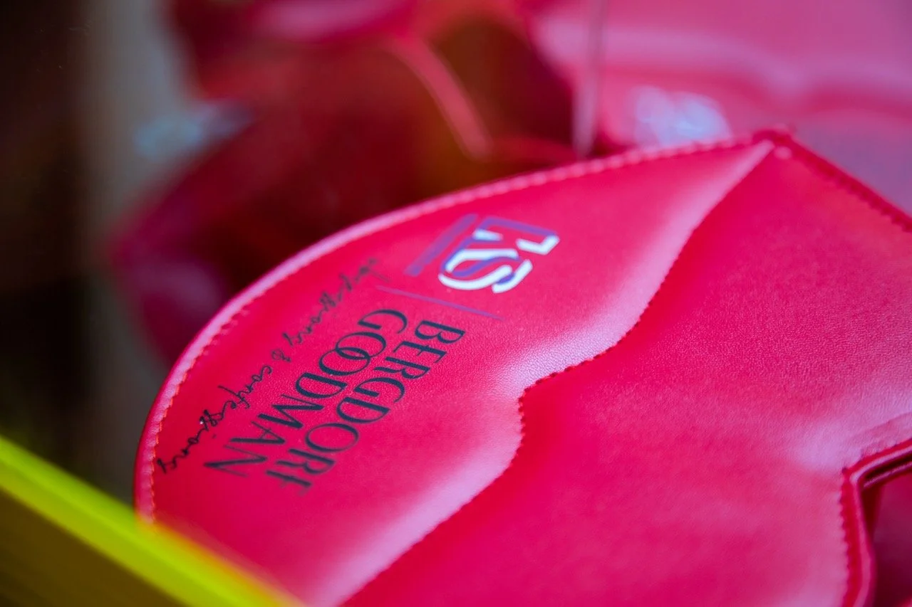 Red pouch in the shape of lips with "BERGDORF GOODMAN" and an "KS" logo prominently displayed. 