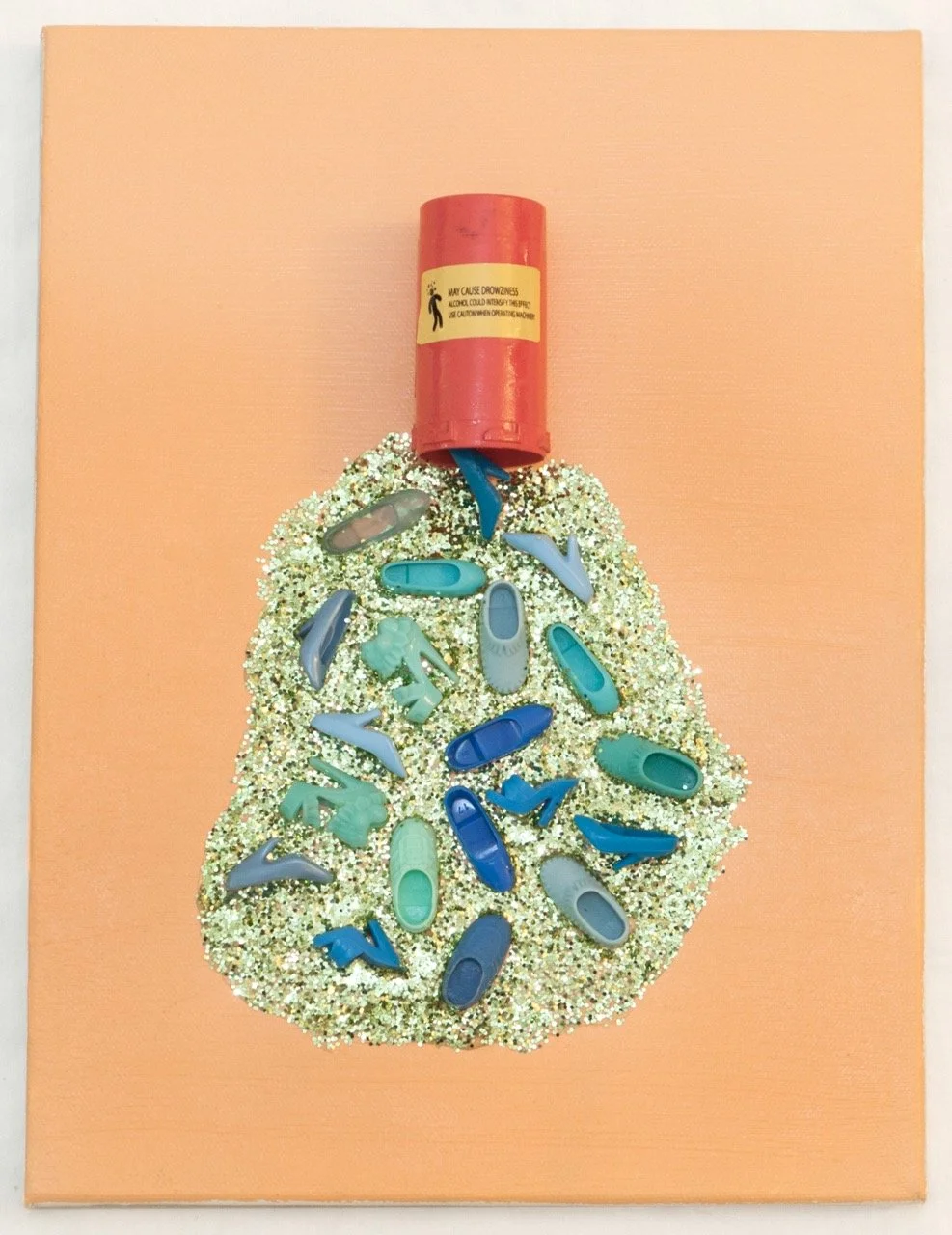 Art piece showing a red pill bottle tipped over, spilling gold glitter and blue-green high-heeled shoes on a peach background. 
