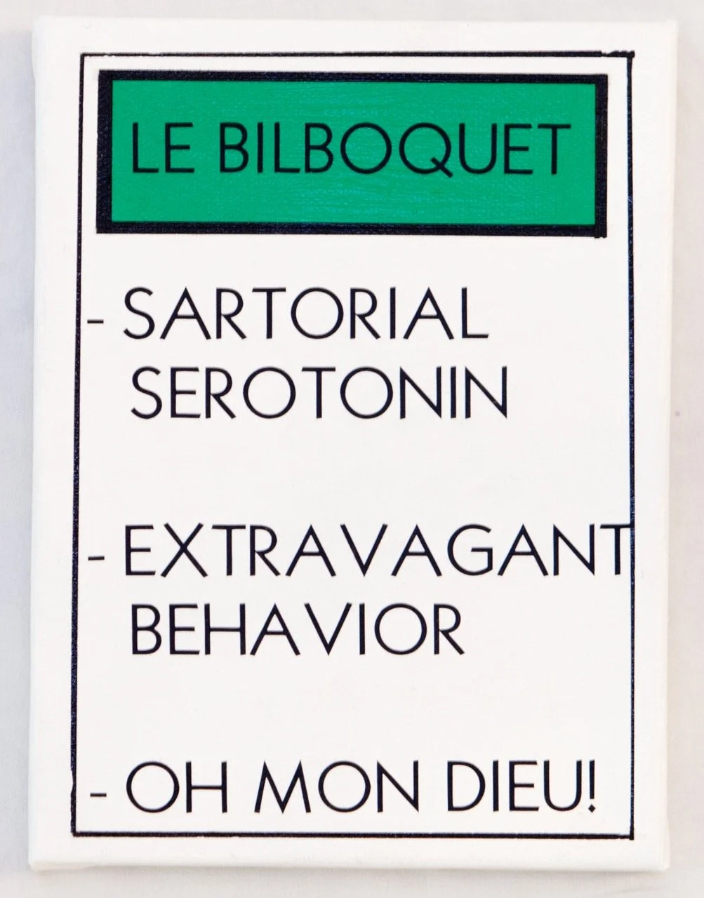 Monopoly property card with a green header reading "LE BILBOQUET." Below are three lines: "SARTORIAL SEROTONIN," "EXTRAVAGANT BEHAVIOR," and "OH MON DIEU!"