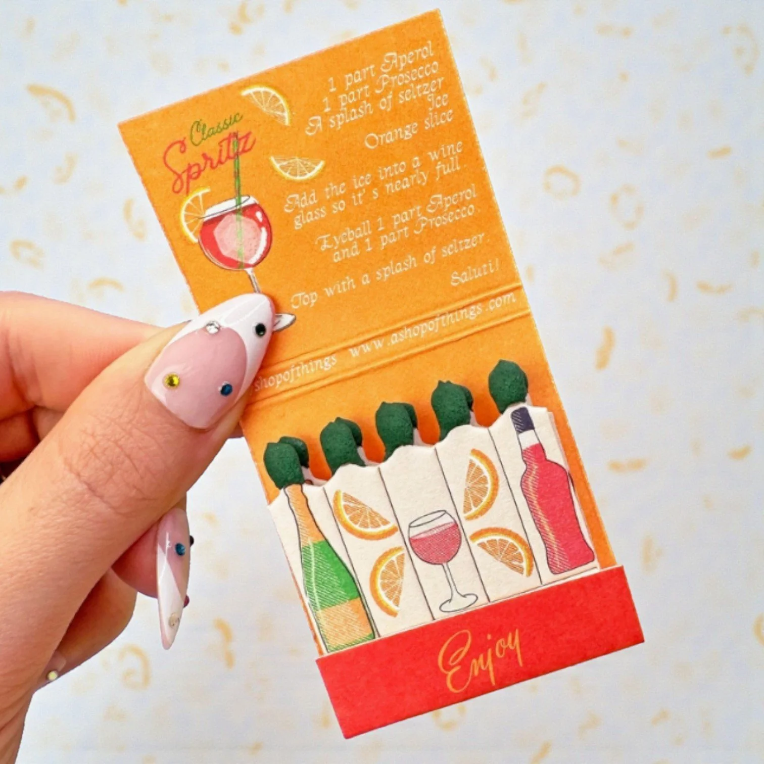 Mini matchbook with Aperol Spritz graphics and retro colors, ideal for bar cart decor or gifting.