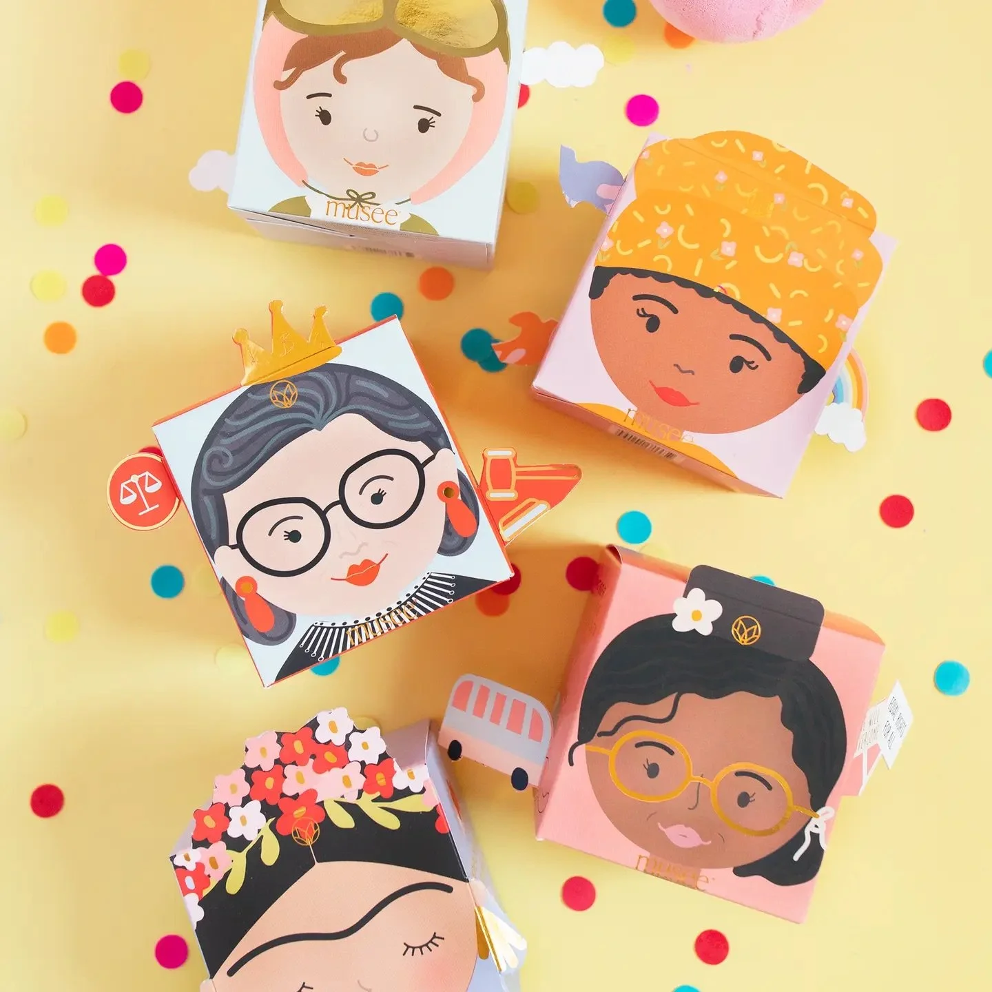 Women's empowerment bath bomb gift set with playful, illustrated packaging and confetti background.