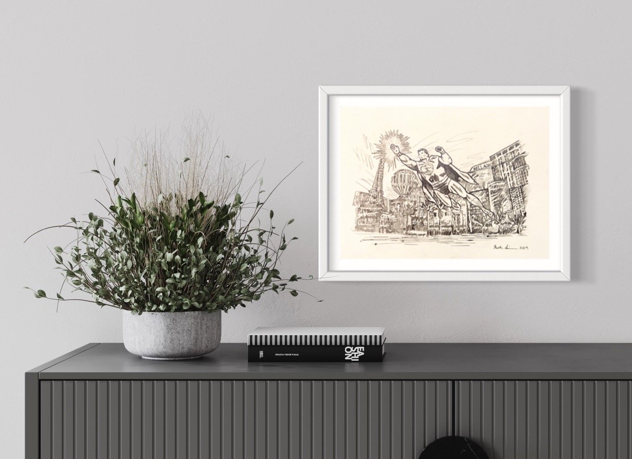 Framed monochrome sketch of a superhero flying over a cityscape, with signature and date at the bottom right