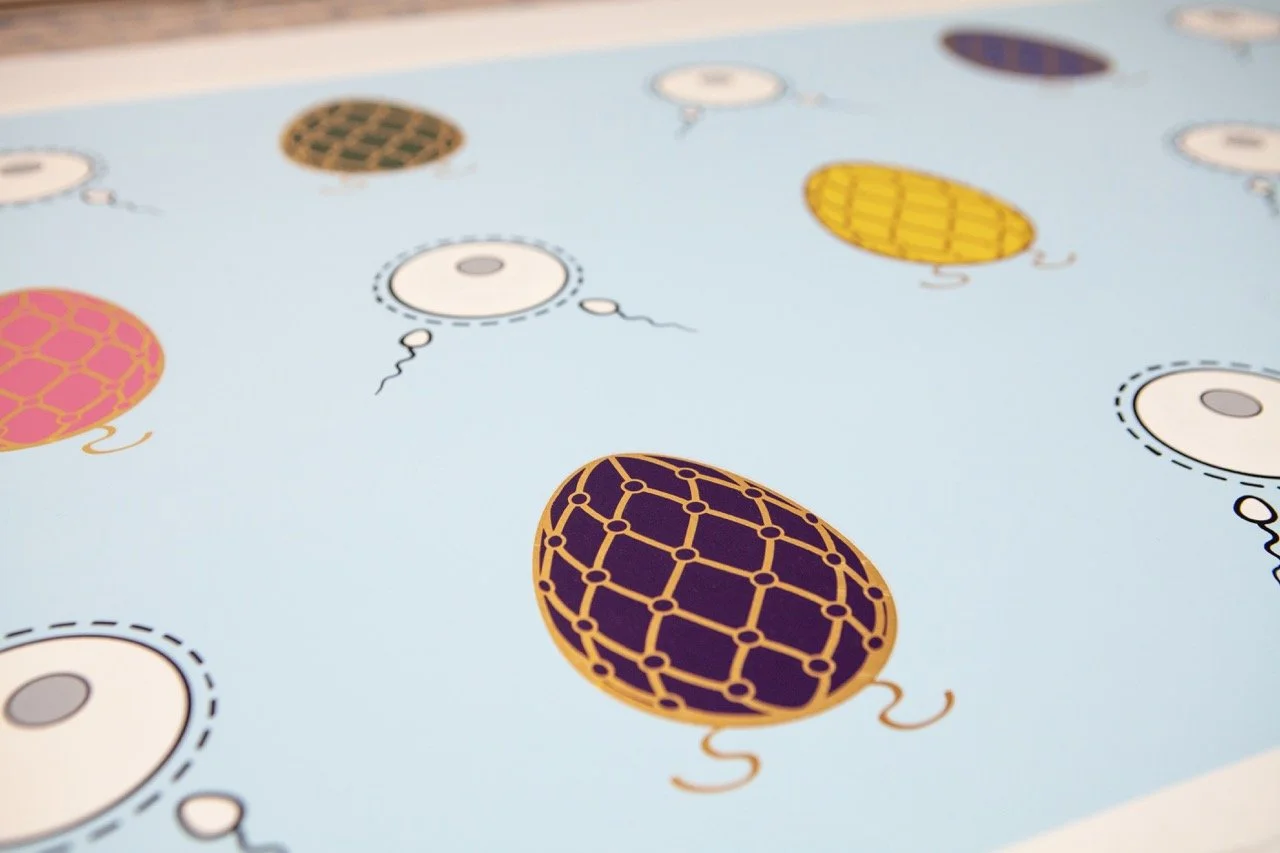 Close-up of a pop art pattern featuring colorful eggs and sperm on a light blue background. The eggs have intricate lattice designs in pink, yellow, green, and purple, with each egg surrounded by stylized sperm illustrations.
