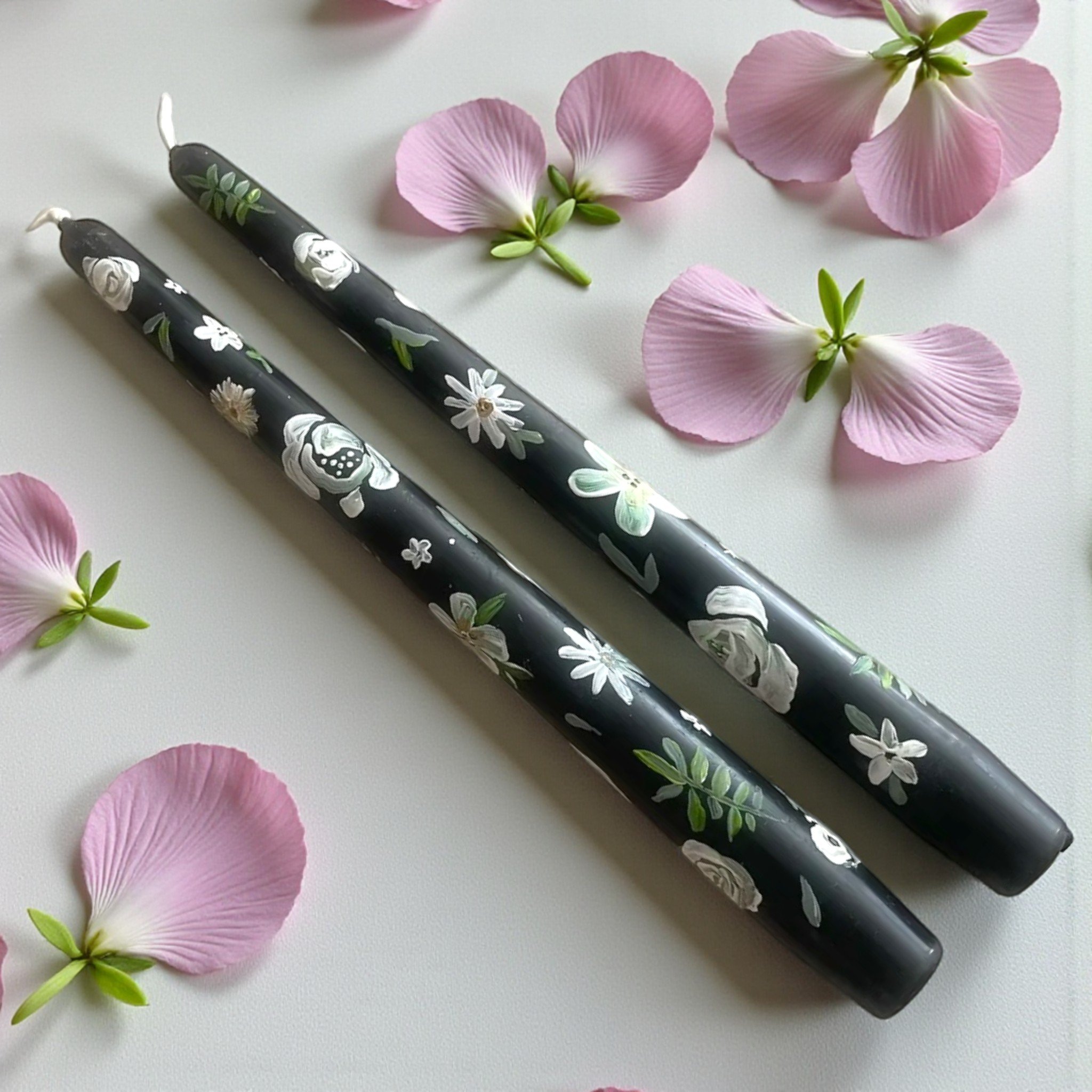 Hand-painted floral black taper candles with delicate white flowers and green leaves