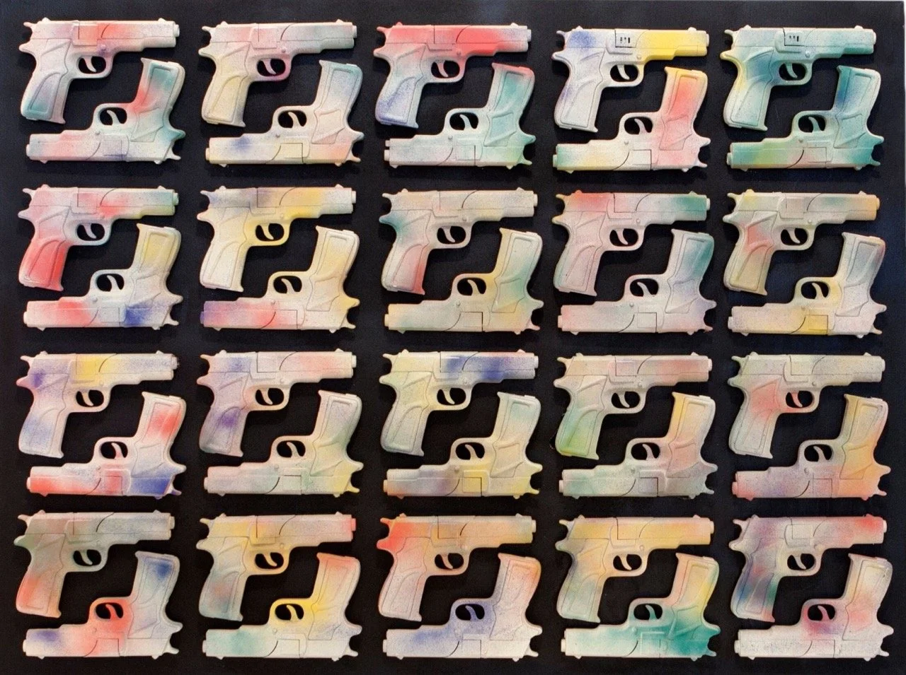 Grid of 40 toy guns arranged on a black background. Each gun is spray-painted with various pastel colors including red, blue, green, and yellow.