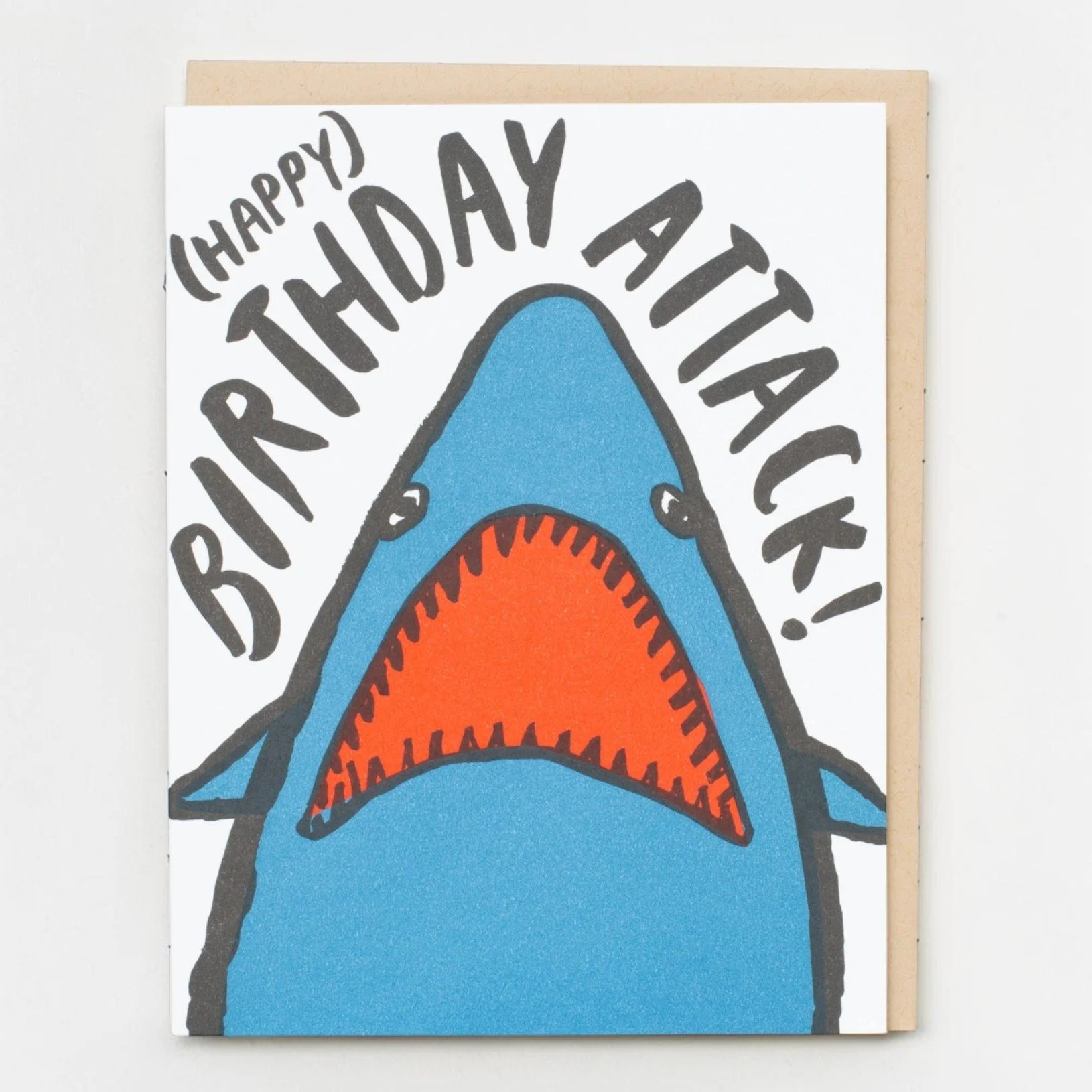 Funny Birthday Attack greeting card with blue shark illustration and kraft envelope