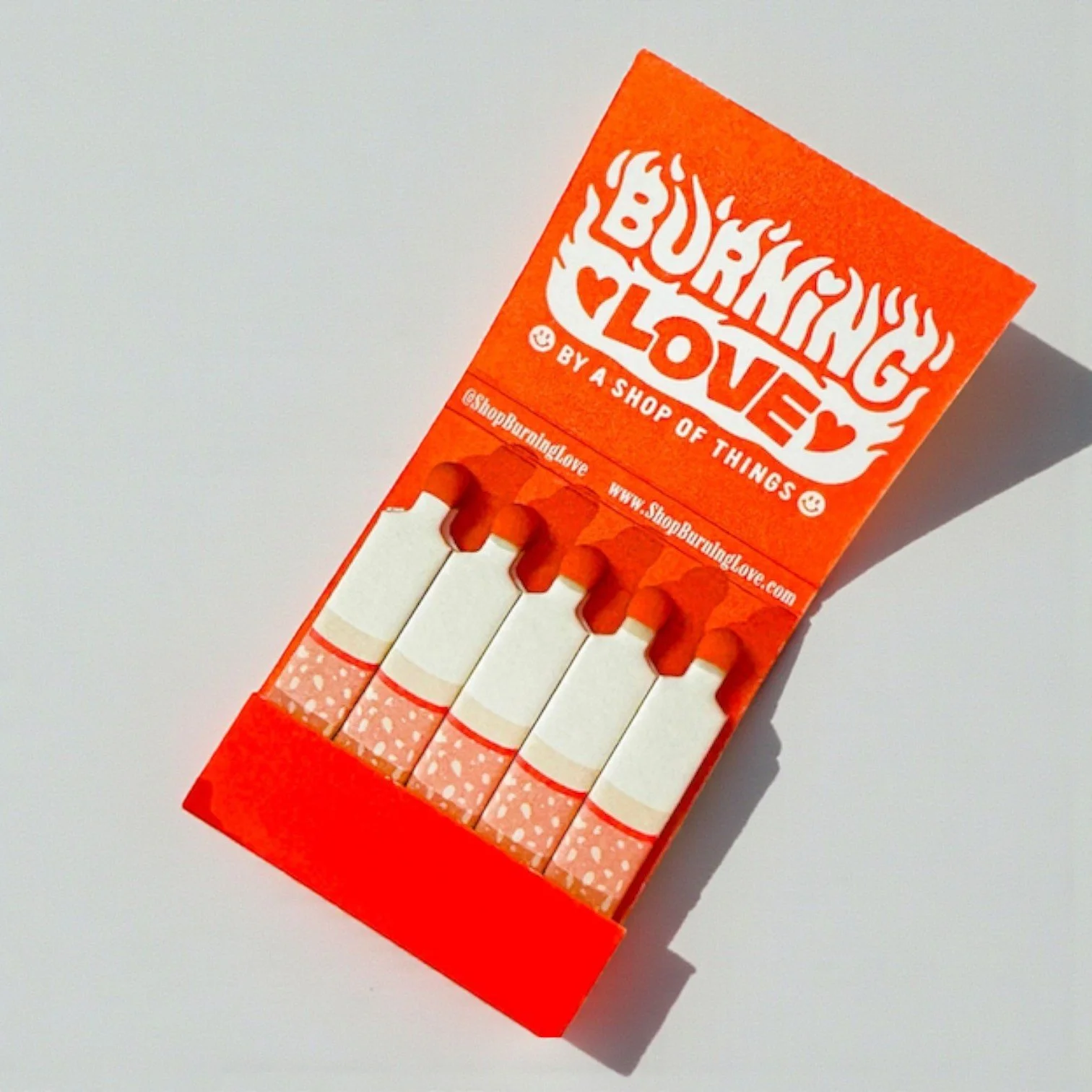 Whimsical matchbook titled “Burning Love” with bold typography and bright red aesthetic.