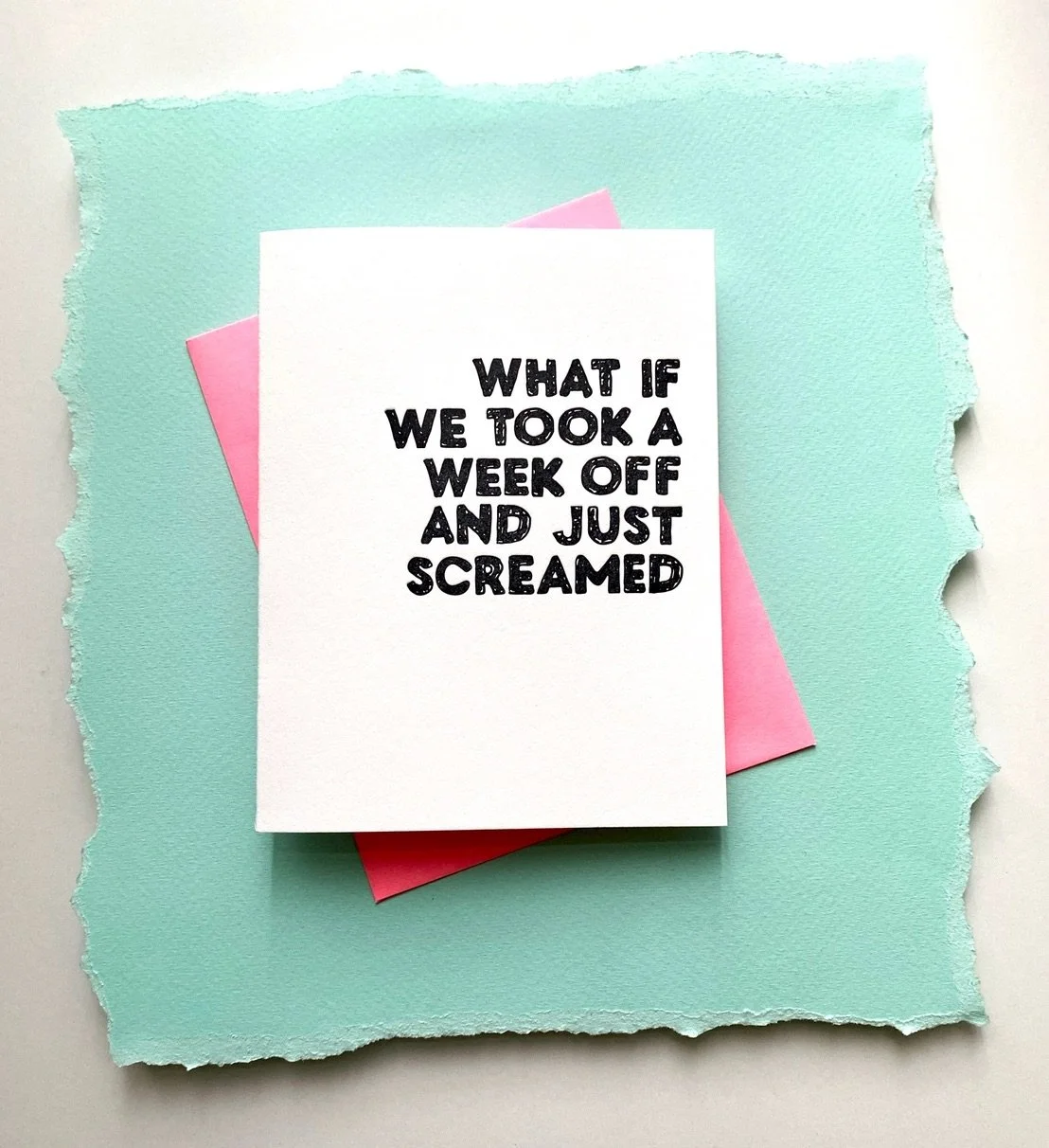 Funny “What if we took a week off and just screamed” greeting card with a pink envelope, photographed on a textured aqua background.