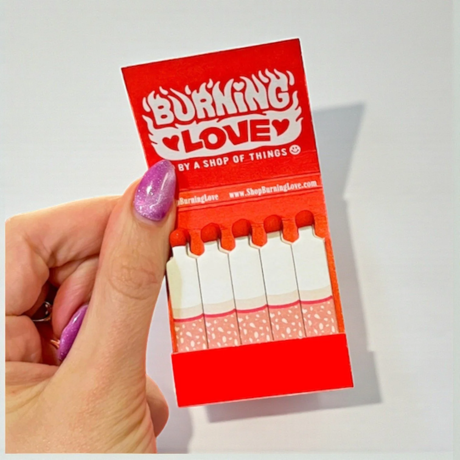 Retro matchbook with bold red graphics and cheeky romantic phrase, designed for humor and style.