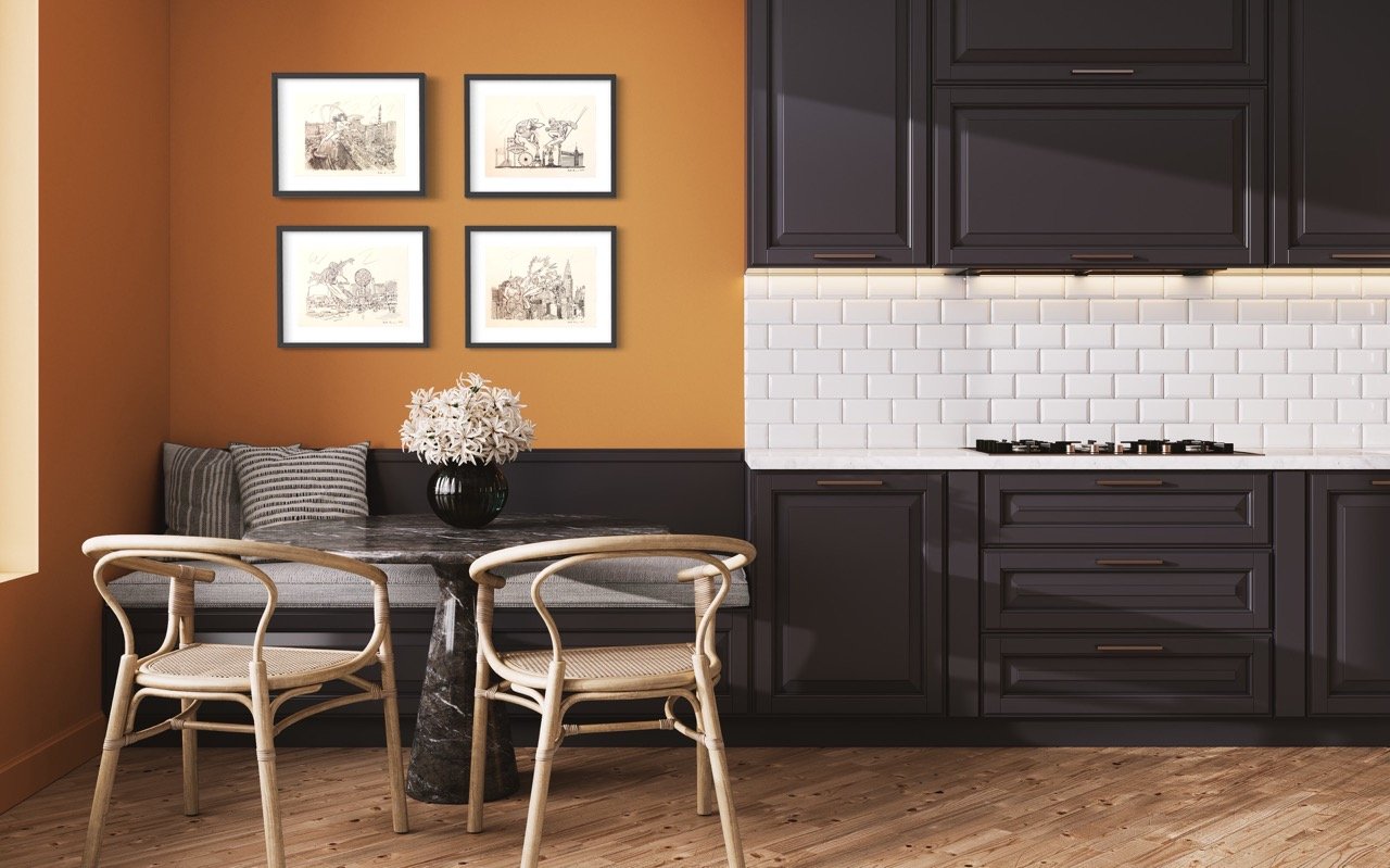 Four black and white superhero sketch artworks on an orange wall above a kitchen bench with striped cushions.