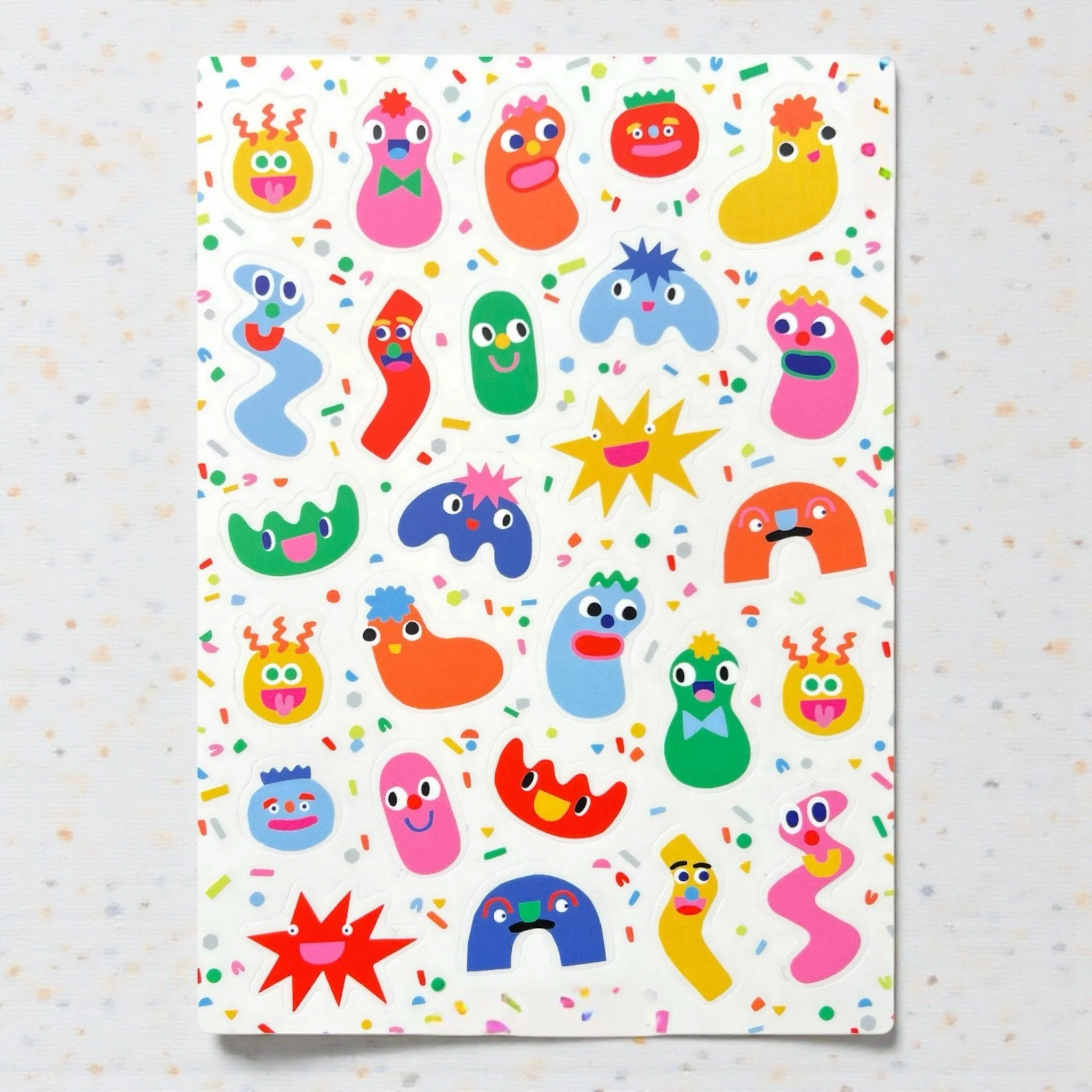 Sticker sheet featuring abstract, colorful blob faces with funny expressions and googly eyes.