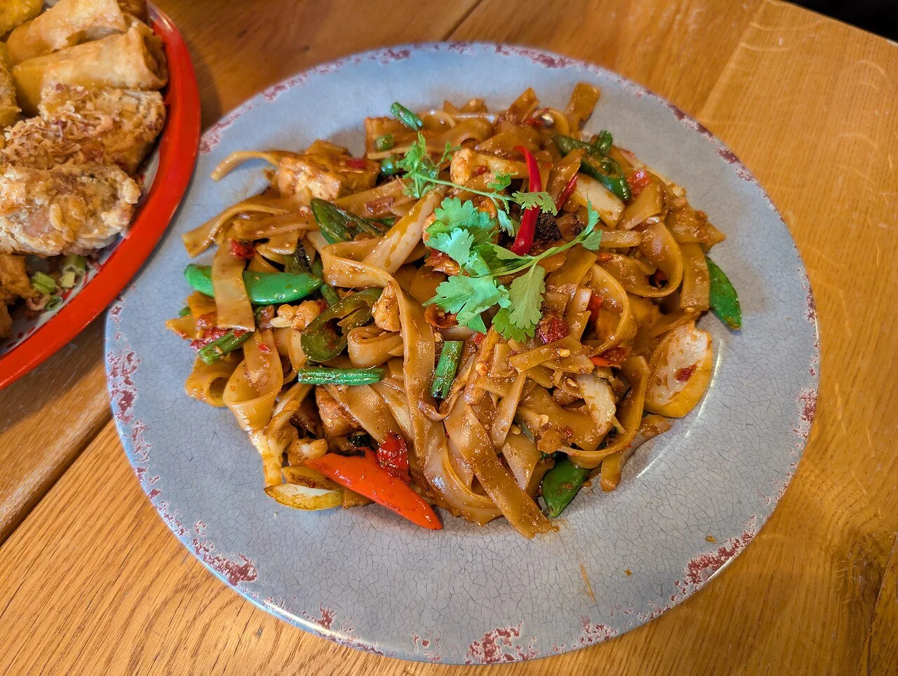 Thai drunken noodles with vegetables, tofu, and basil
