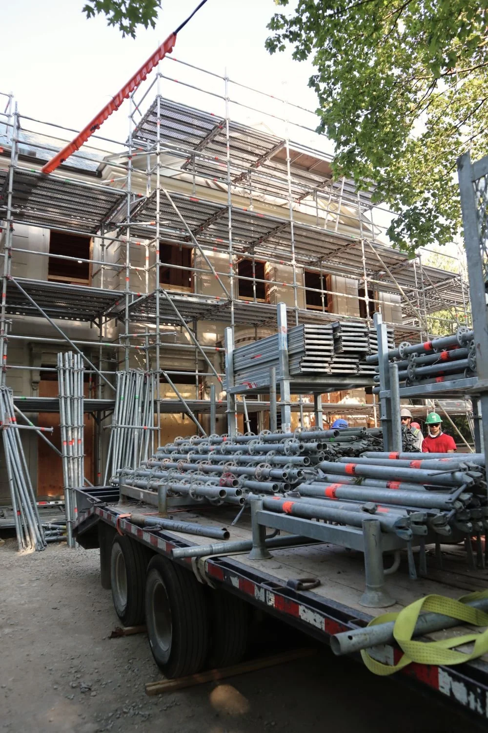 Scaffold installation on house with tarps