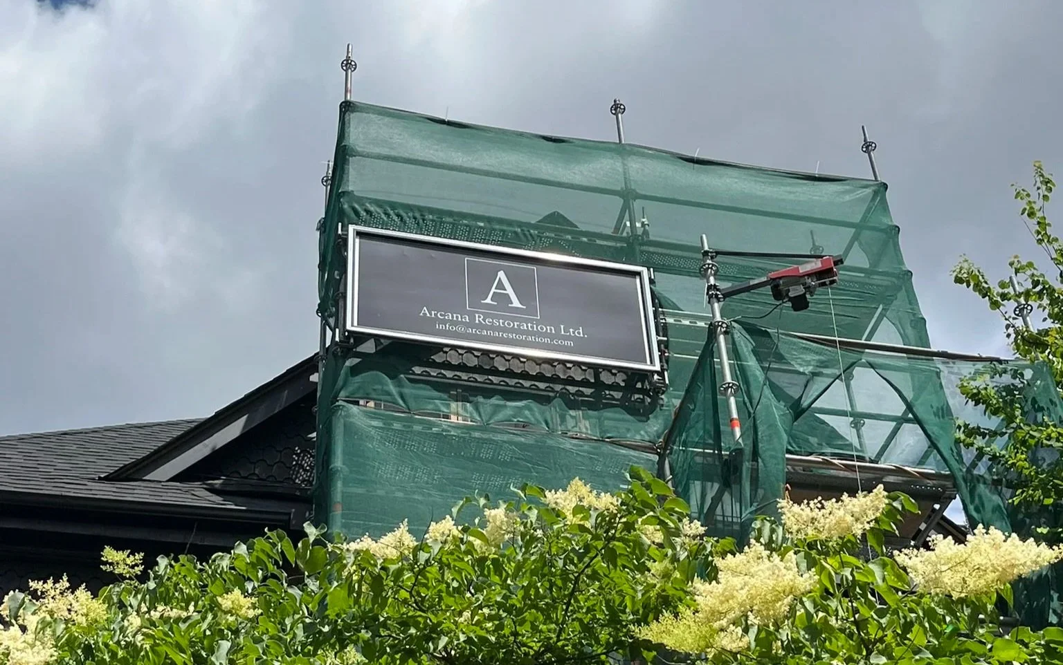 Metal scaffold sign installed on a scaffold for Arcana Restoration