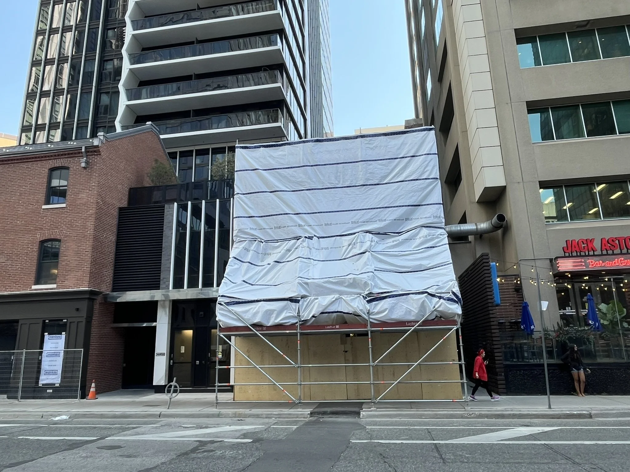 Front of scaffolding installation with tarps and public access protection on downtown Yonge St in Toronto