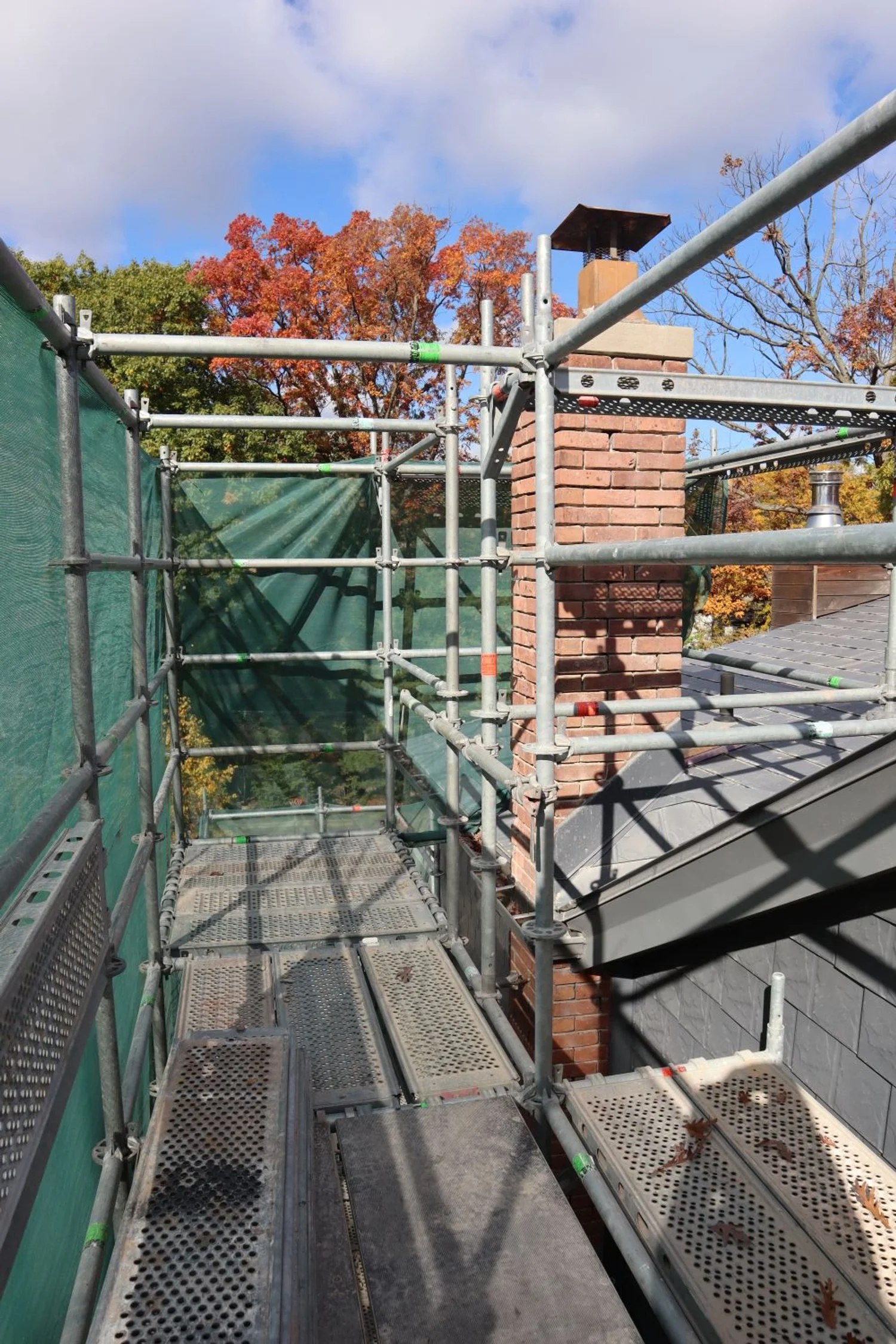 Rental scaffold with dust netting around chimney for construction access Toronto