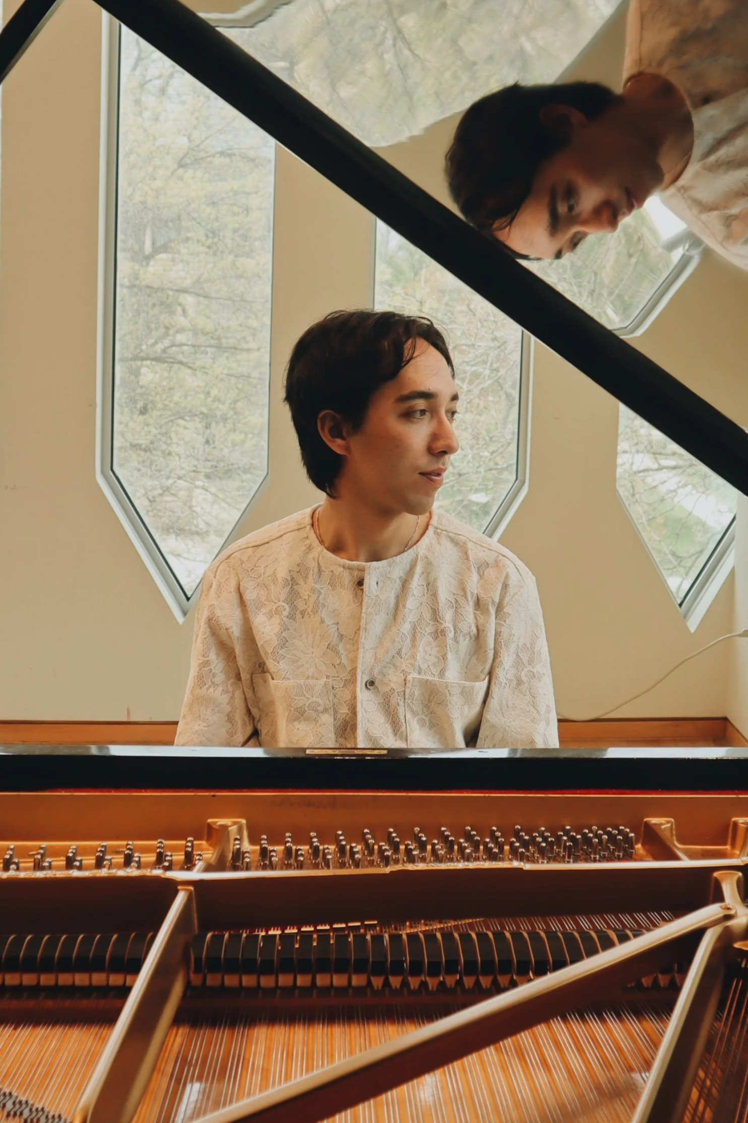 Piano and English teacher Kenji Kurabayashi seated at piano