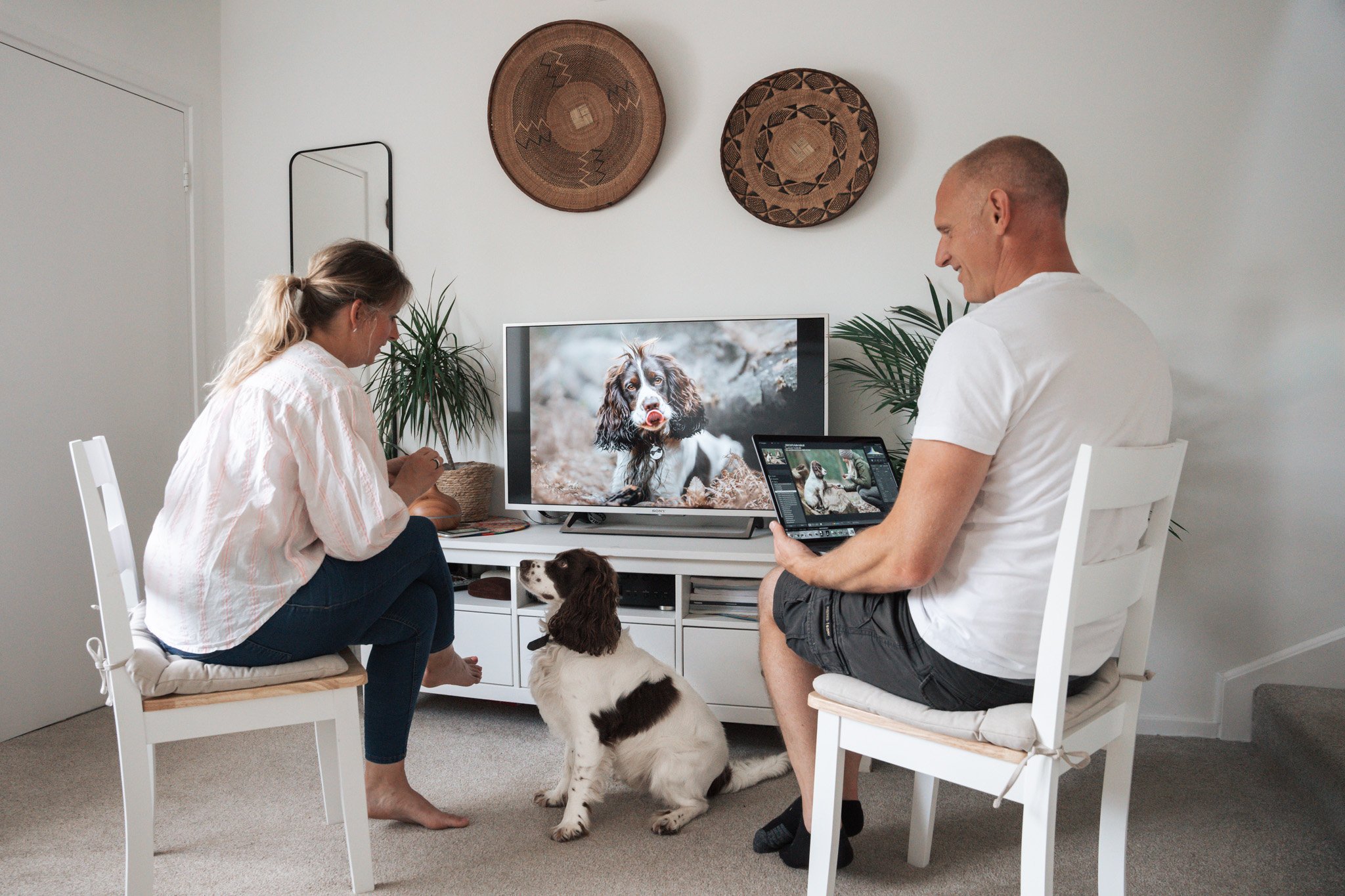 Client and her Cocker Spaniel viewing final images on a TV while the photographer shows additional images on a laptop during a session with KnightPics Photography